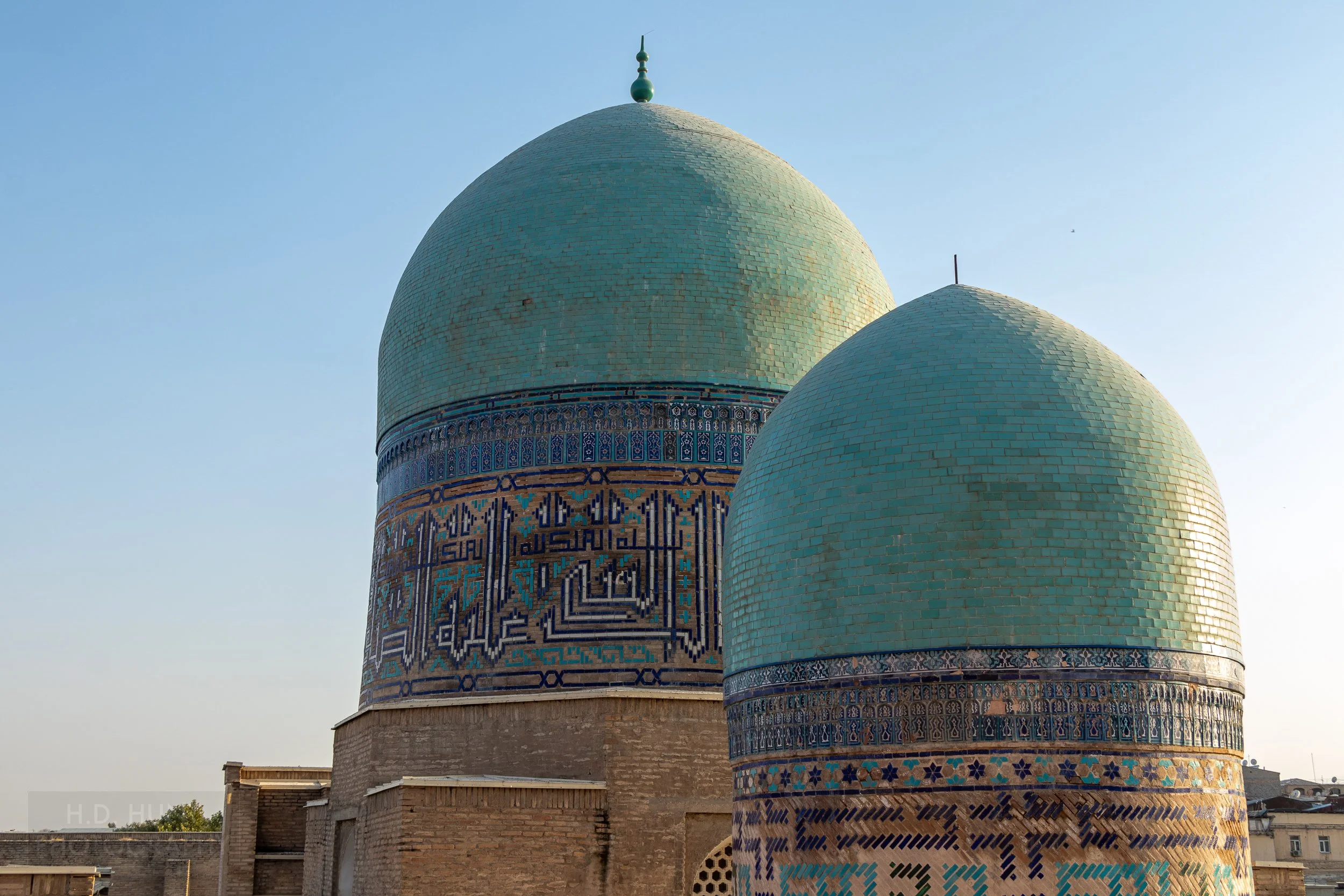 Two green tiled exterior domes of the Kazi Zade Rumi mausoleum at the Shah-i-Zinda necropolis in Samarkand, Uzbekistan.