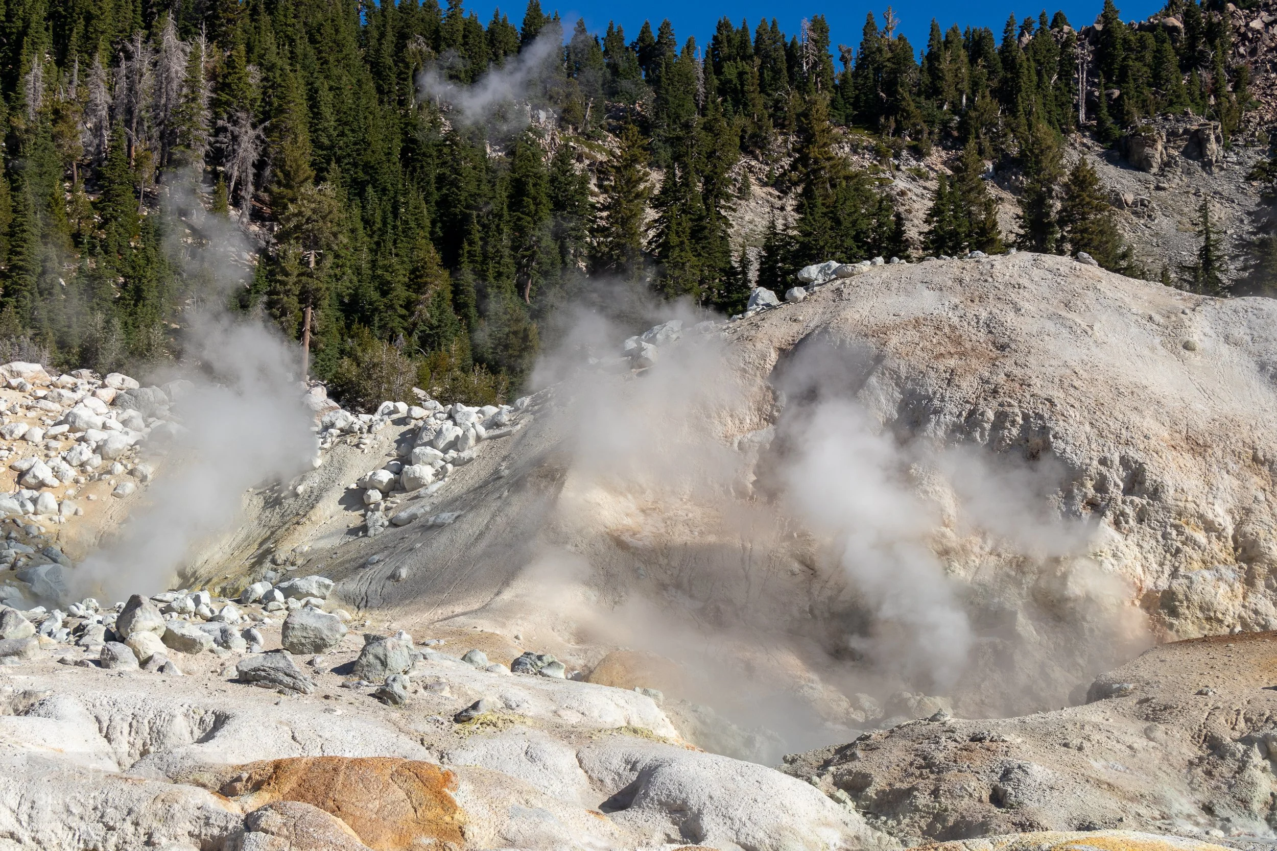 Steam rises from multiple holes in the earth, Bumpass Hell, Lassen Volcanic National Park, California, United States.