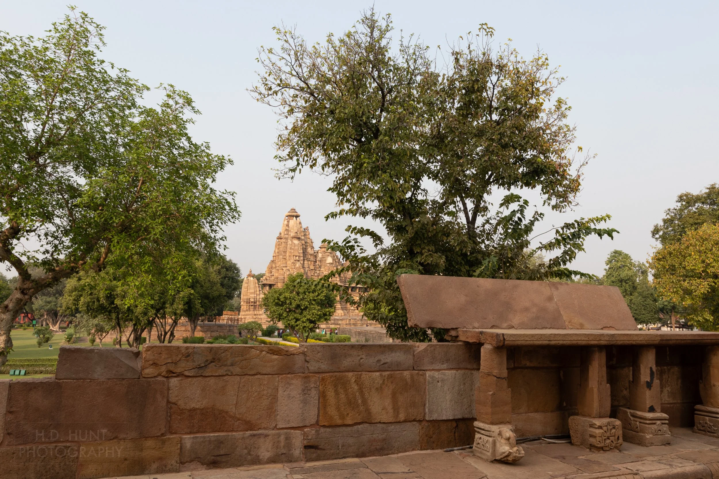 The Vishvanatha Temple rises above a small stone wall, Khajuraho Group of Monuments, India.