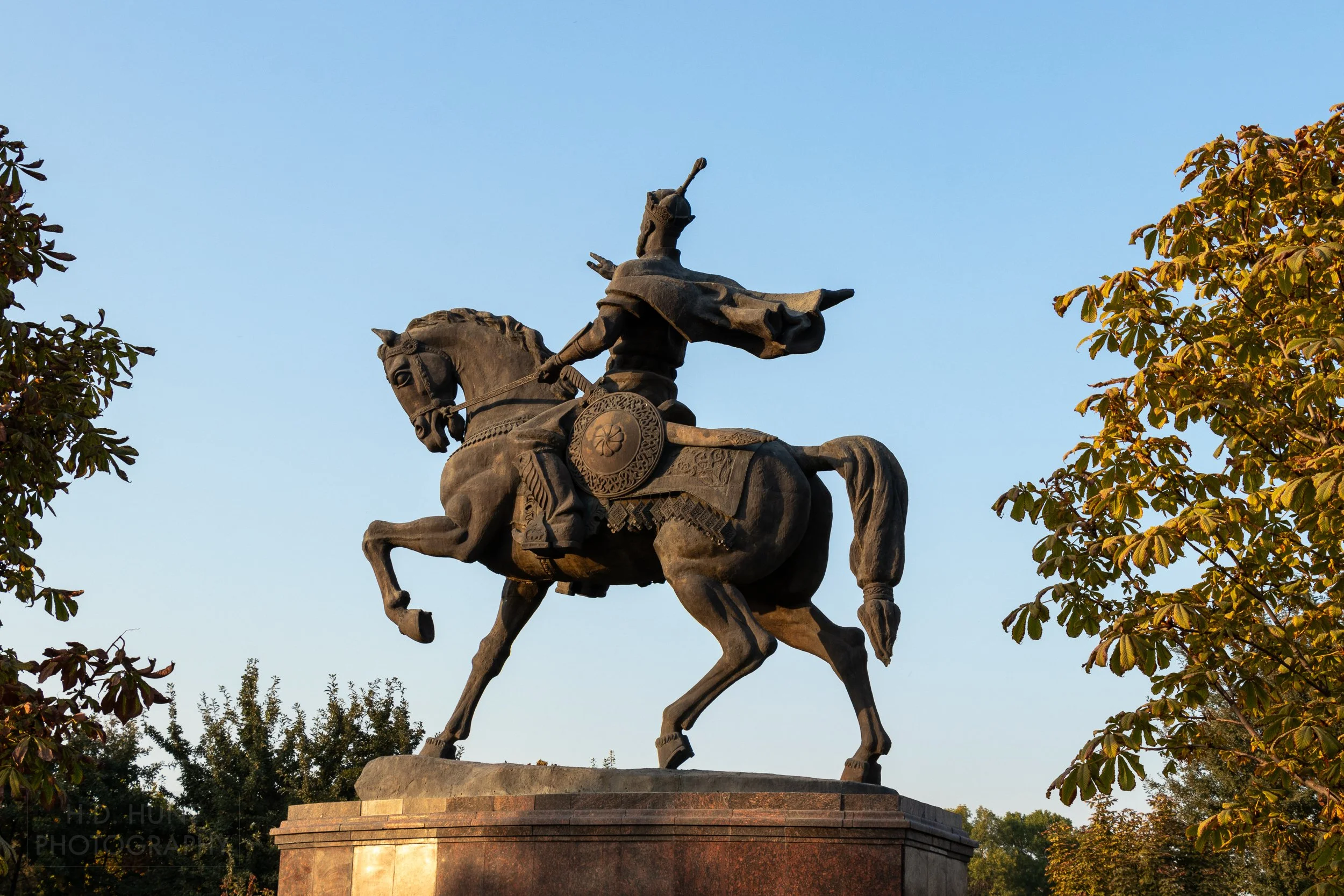 A large statue depicting Amir Temur on horseback sits atop a large stone pedestal in Tashkent, Uzbekistan.