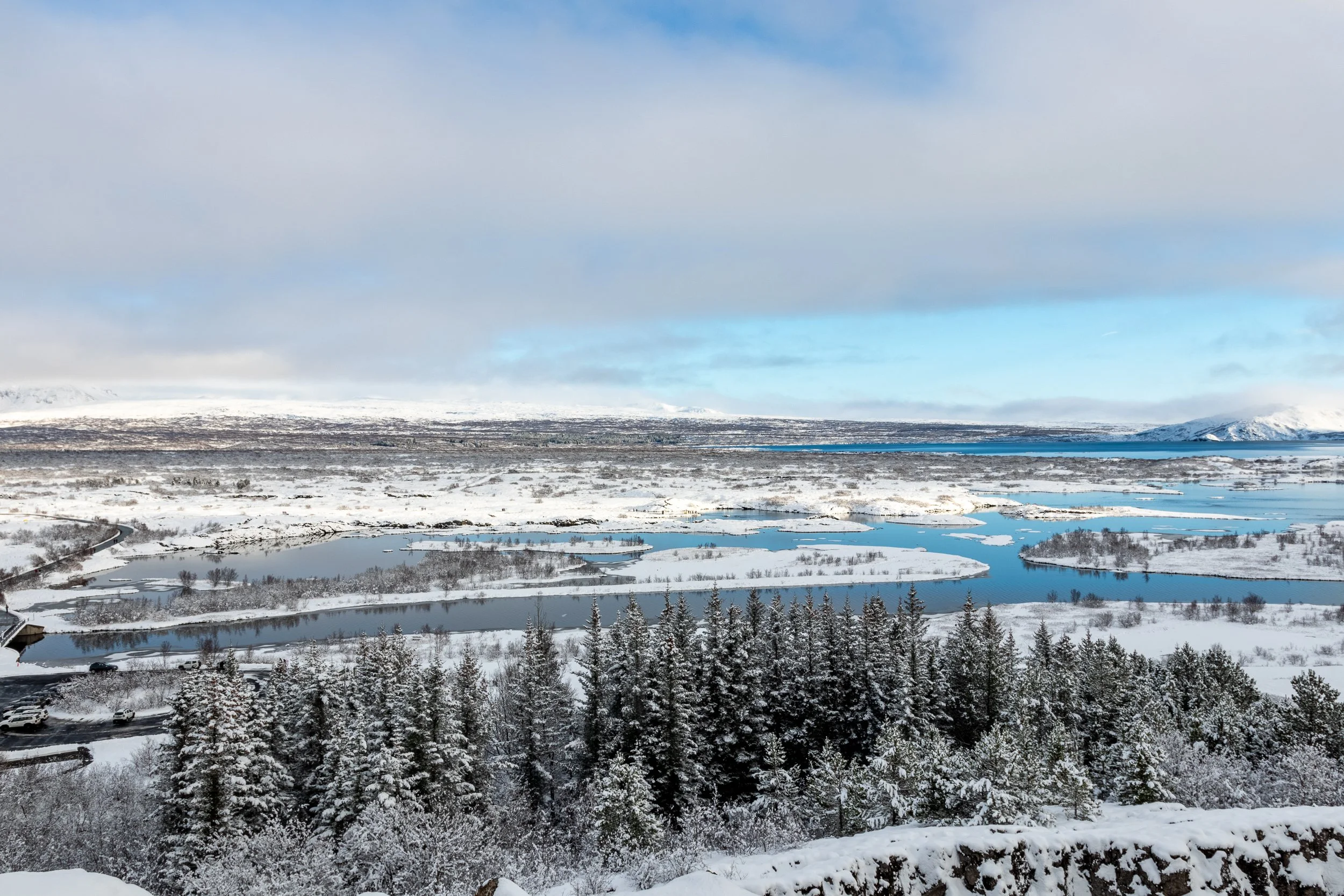 A river carves through snow-covered lowlands at Þingvellir, Iceland.