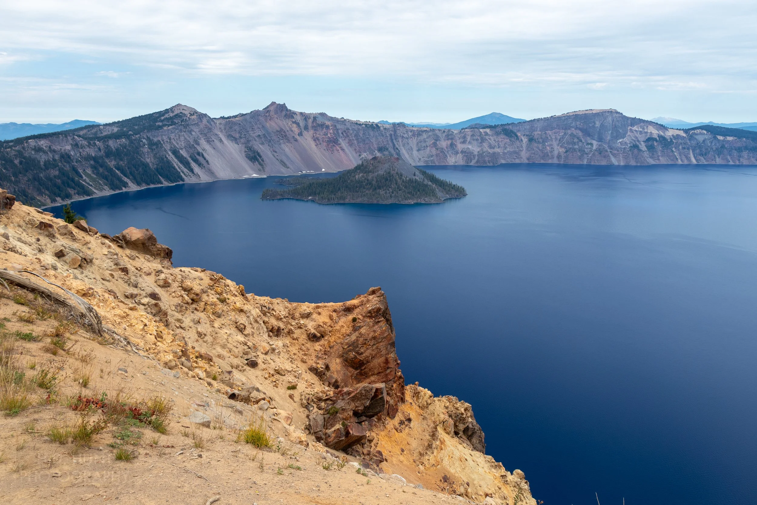 A view of the blue waters of Crater Lake with Wizard Island in the background from the trail up Garfield Peak, Crater Lake National Park, Oregon, United States.