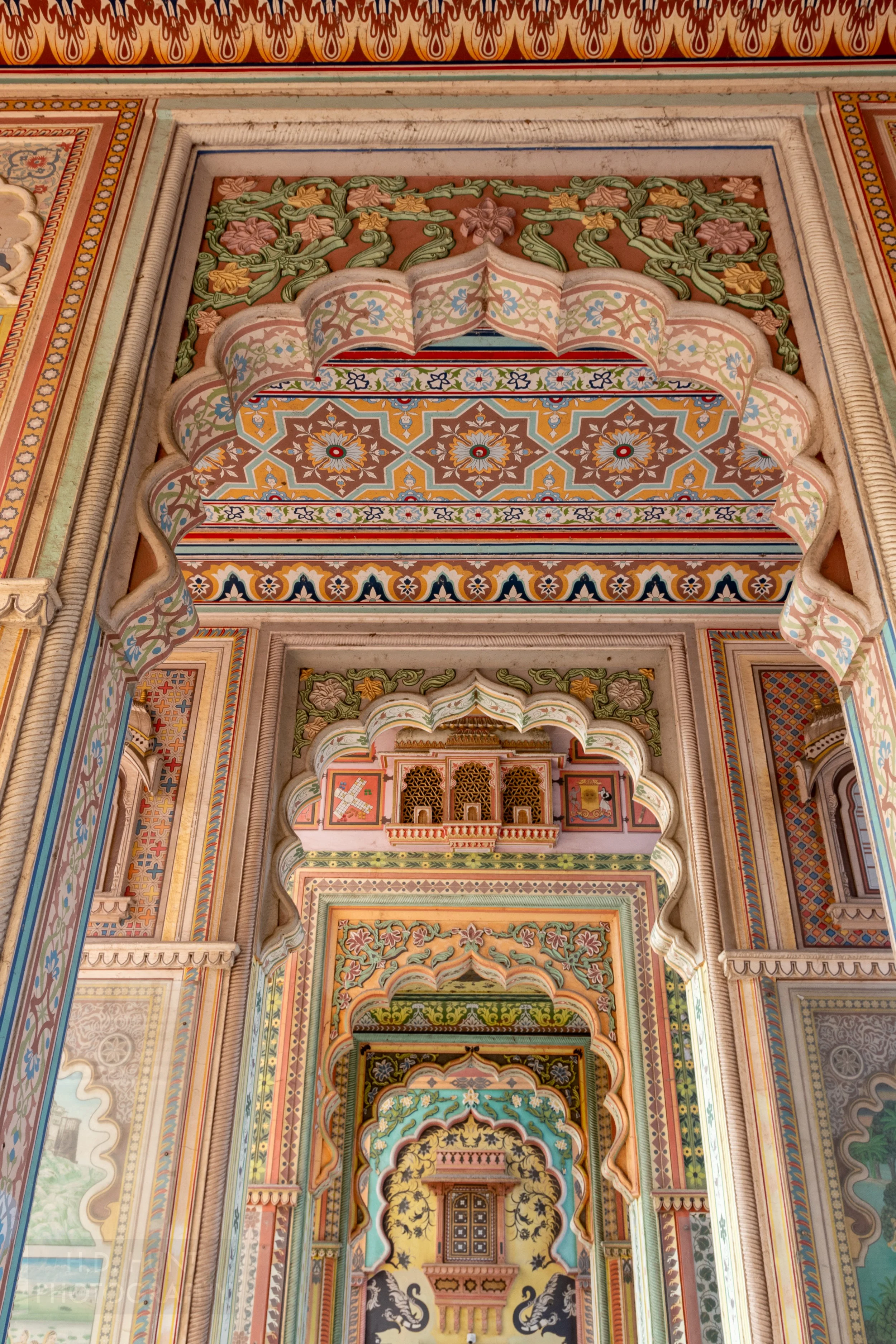 Multi-colored walls are seen through multiple arches at the Patrika Gate, Jaipur, India.