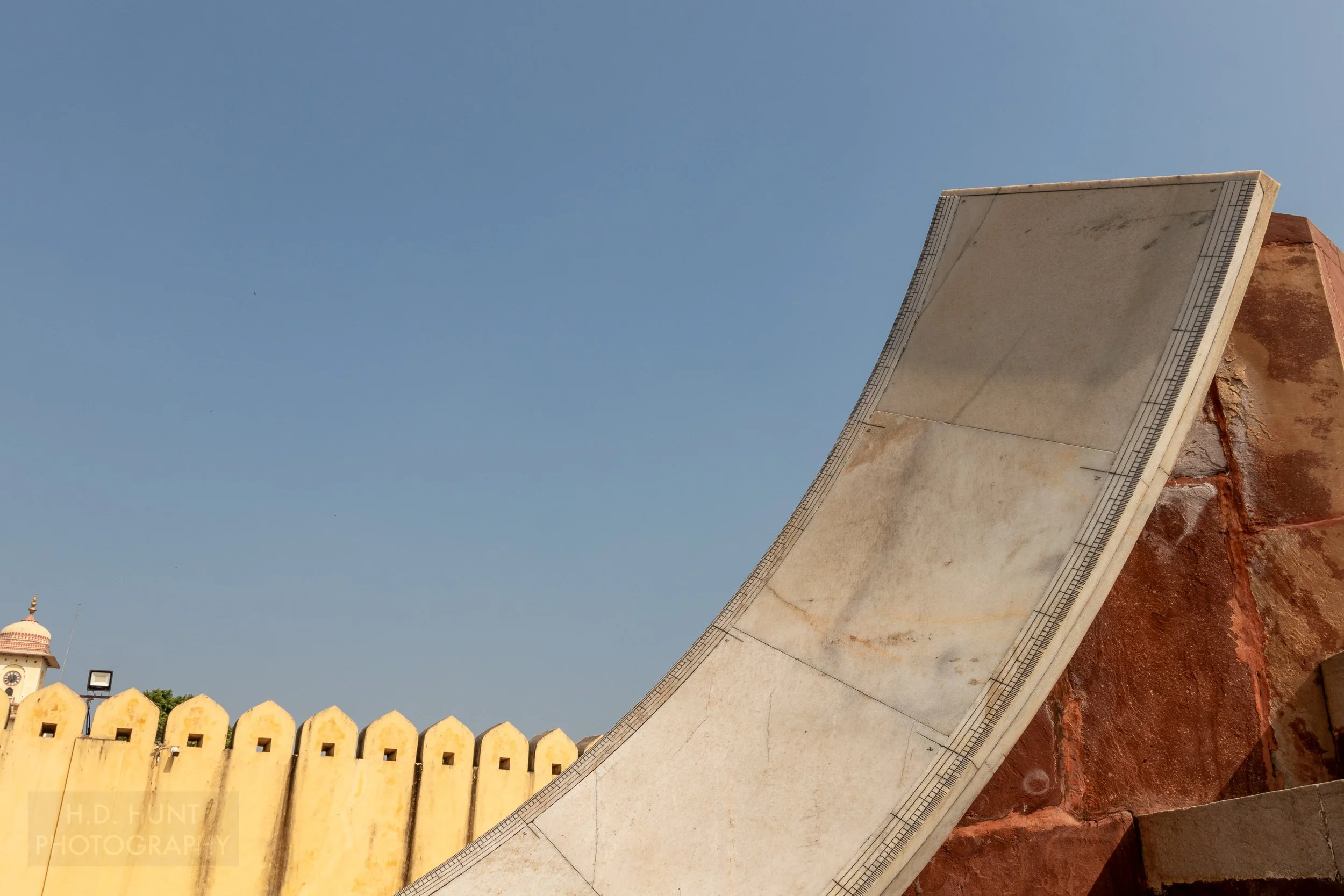 A large white stone arc with black markings on its edge is see at Jantar Mantar, Jaipur, India.