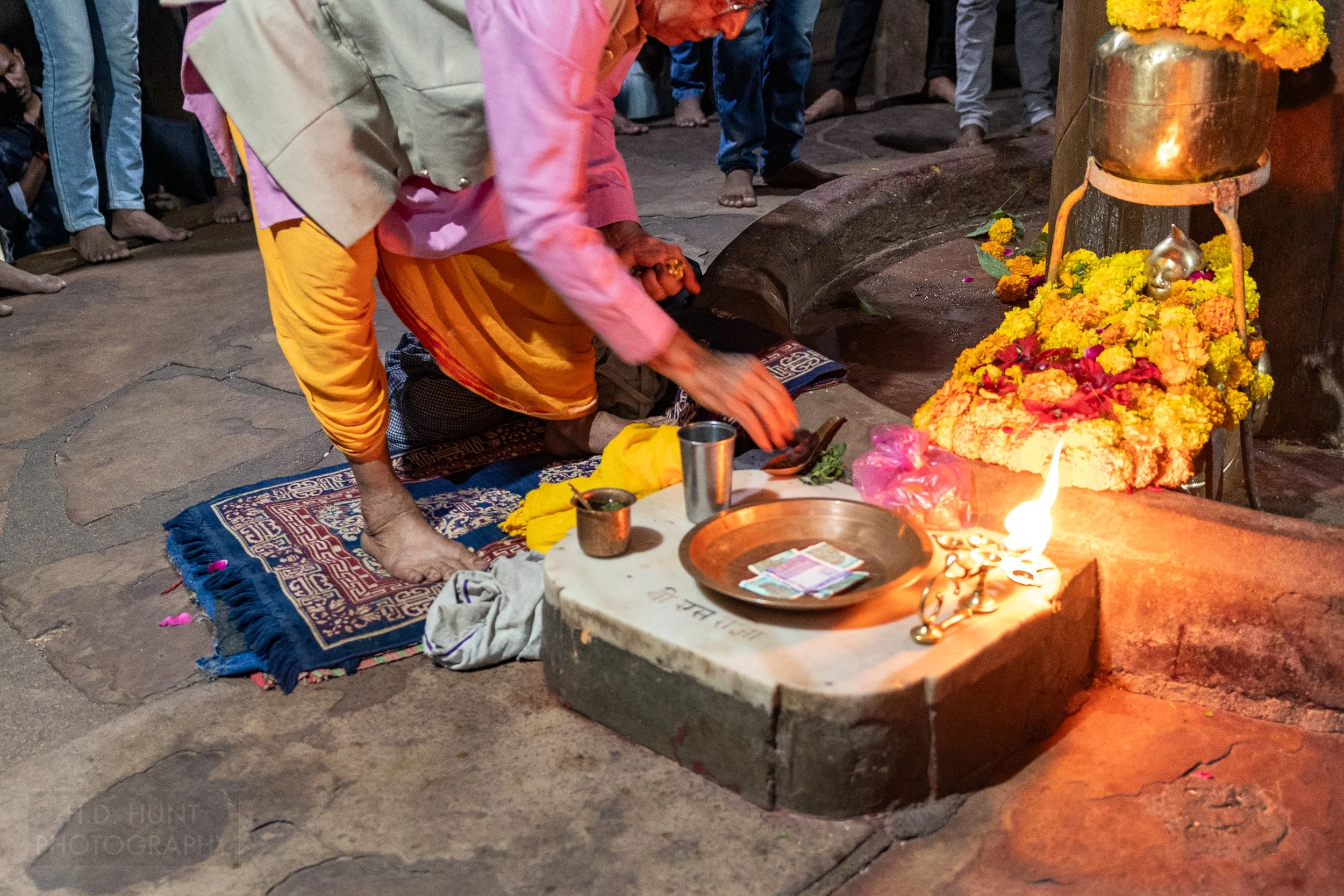 A man gives an offering during a religious ceremony inside the stone Matangeshvara Temple building, Khajuraho, India.