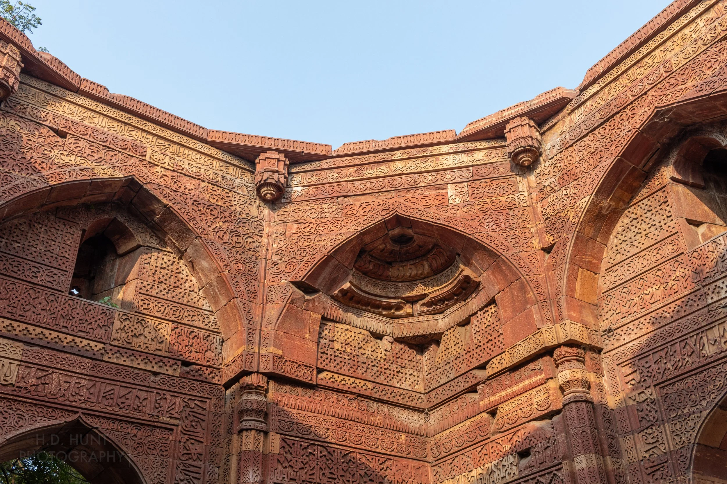 An intricately carved stone facade within the Qutub Minar complex, Delhi, India.