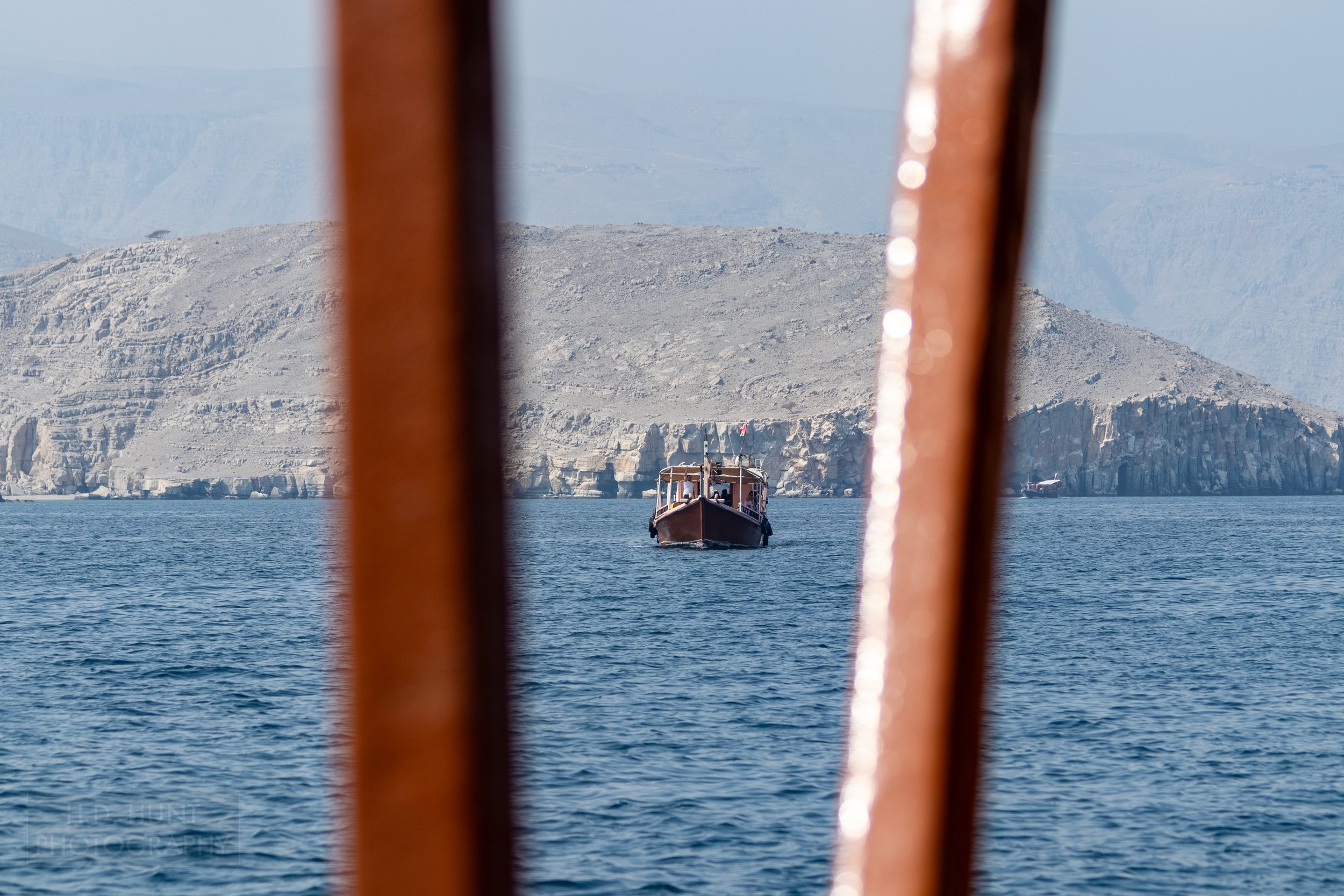 A dhow boat is seen in the distance in the waters off the Musandam Peninsula, Oman