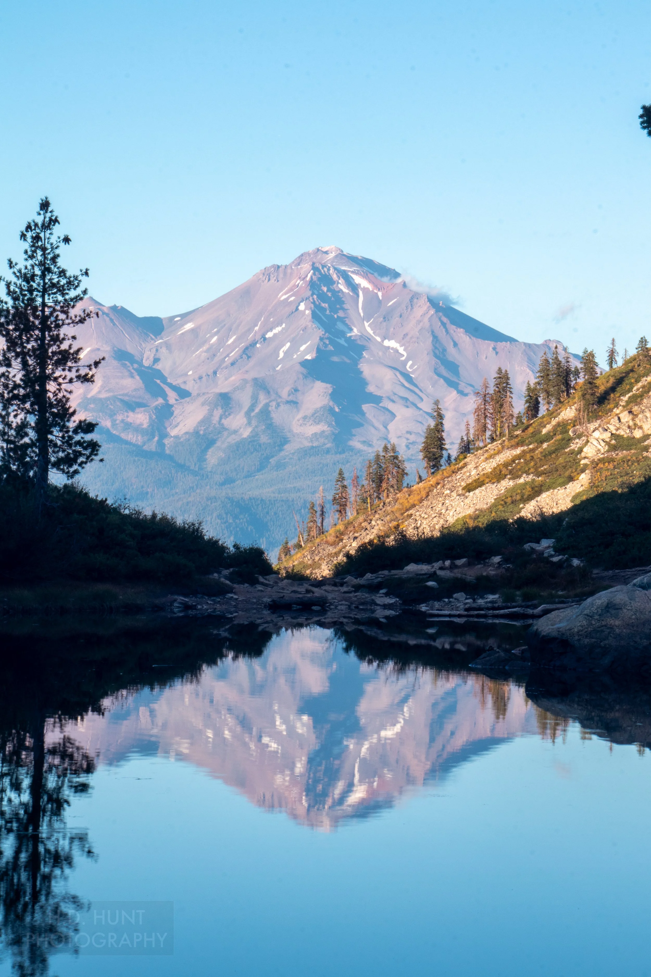Mount Shasta is reflected in a small lake, Shasta-Trinity National Forest, California, United States.