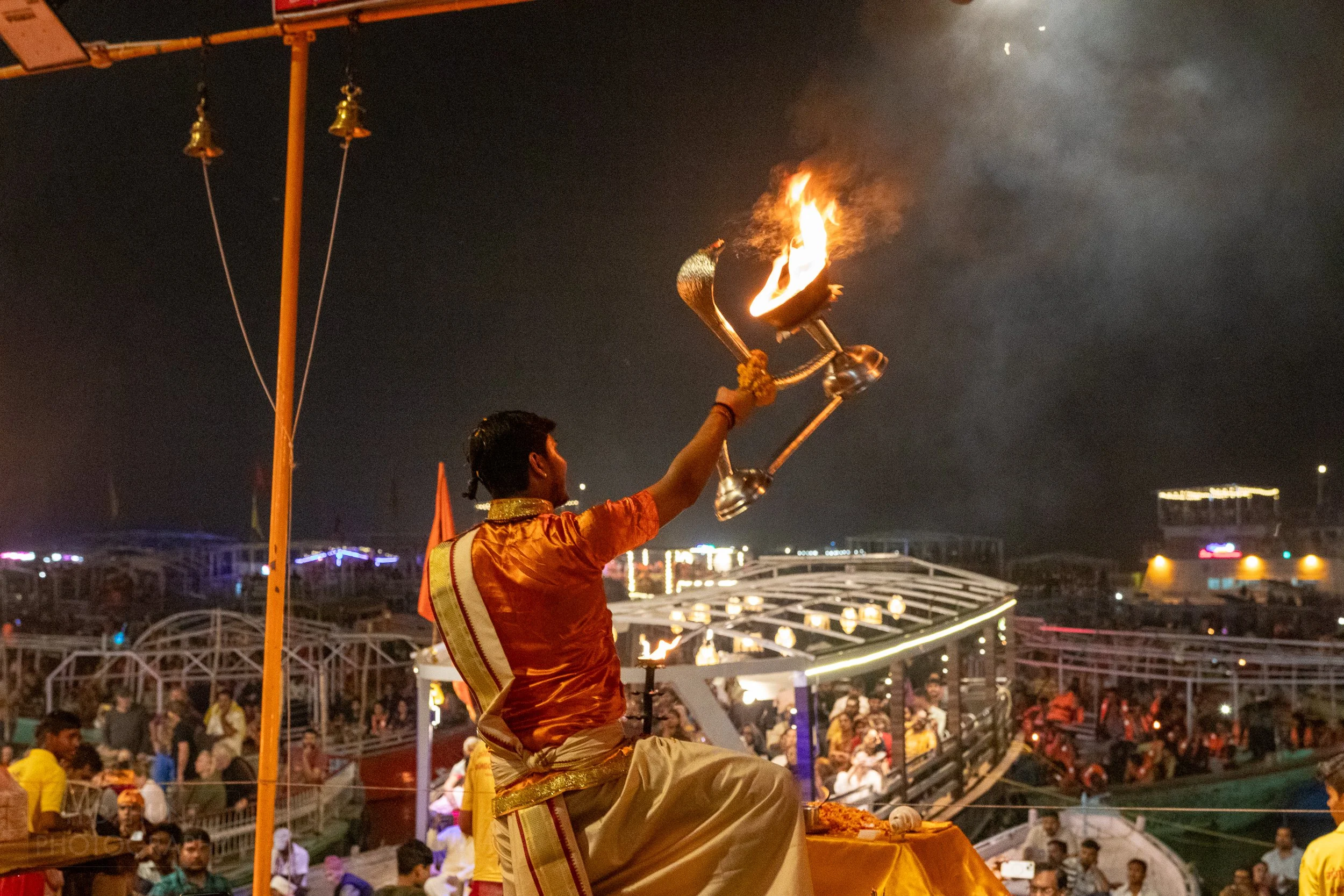 A man holds a large lit lantern above his head during a Hindu religious ceremony called arti, Varanasi, India.
