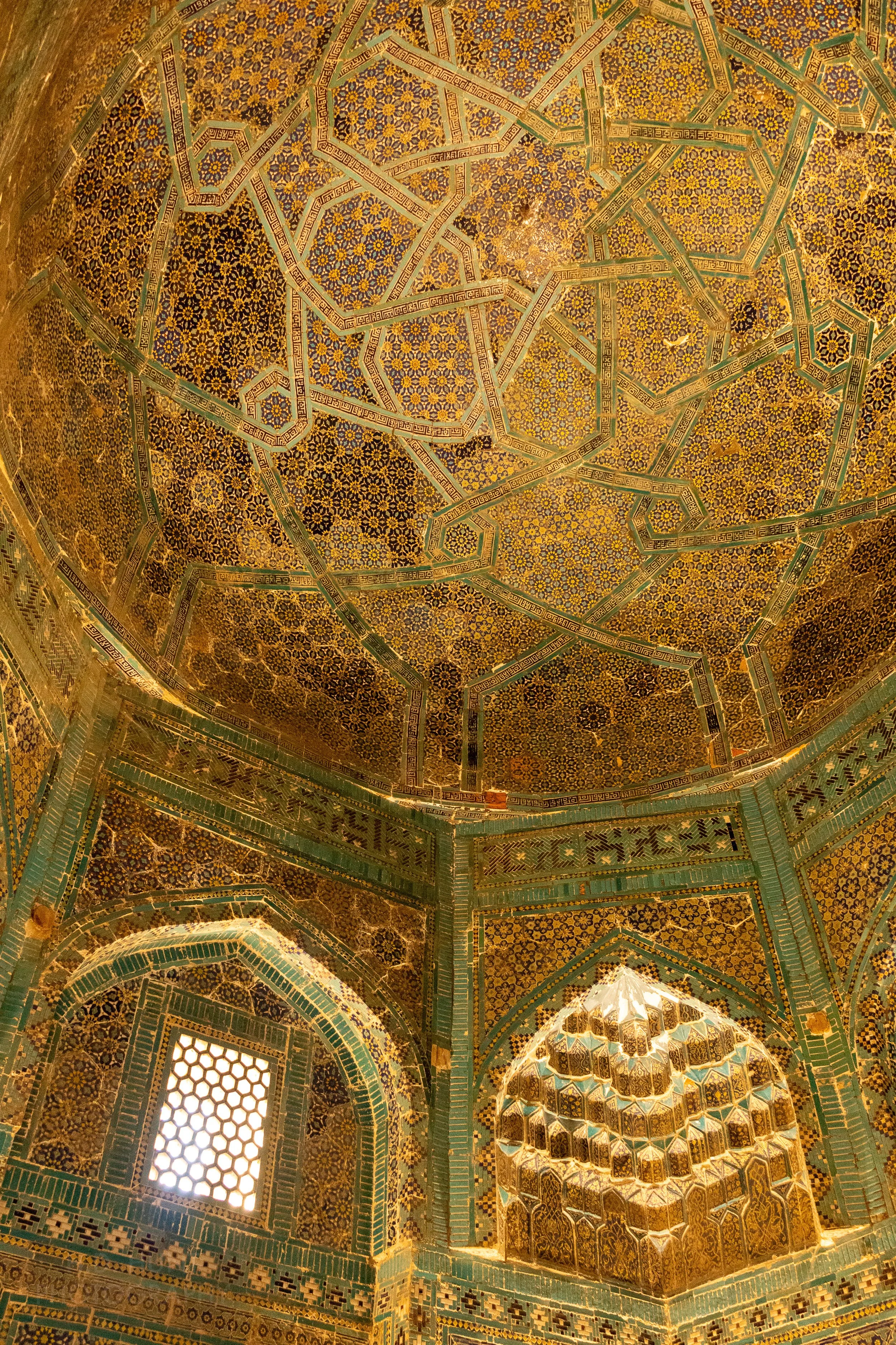 Ornate gold and green tiled dome interior at the Shah-i-Zinda necropolis in Samarkand, Uzbekistan.