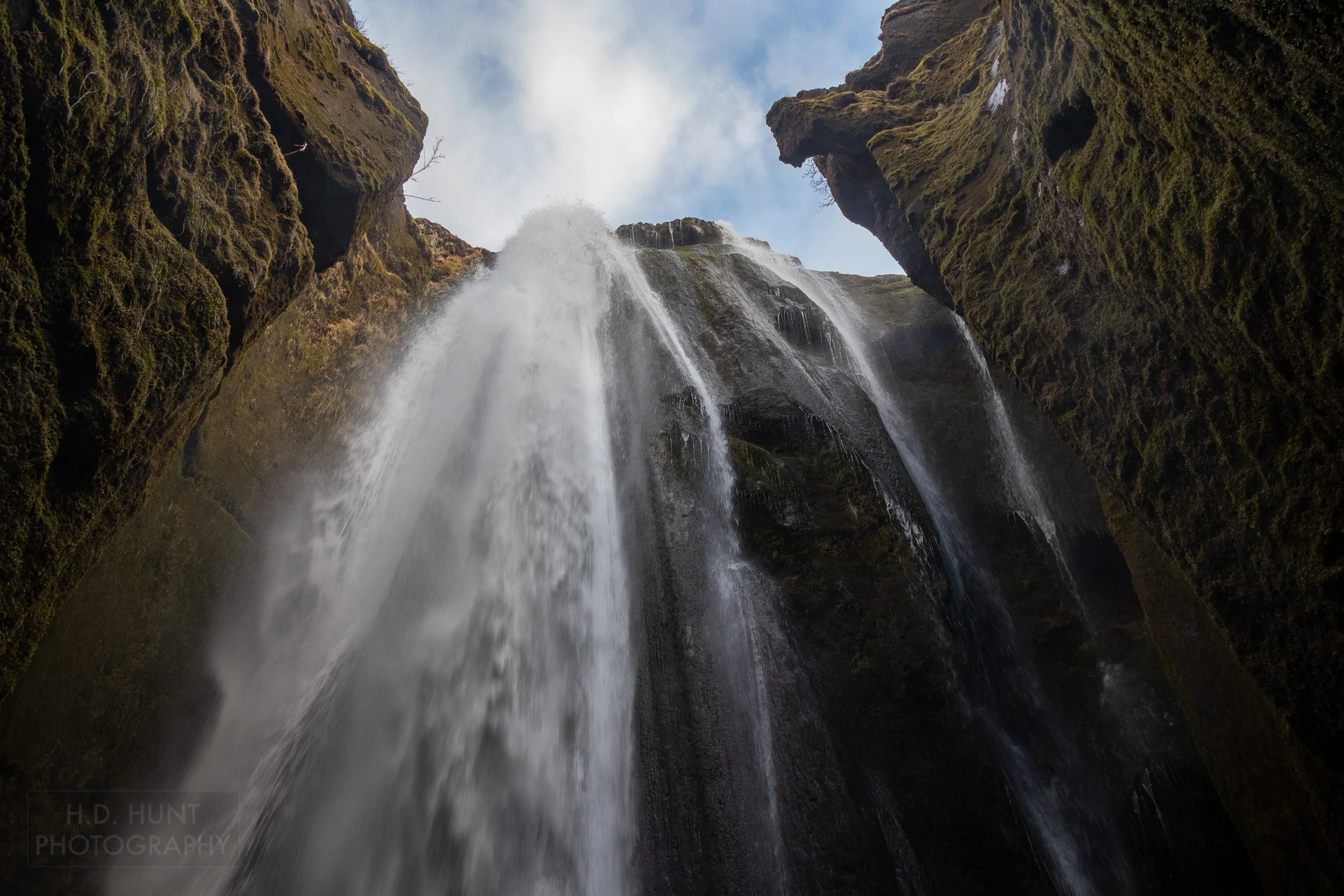 Ringed by tall rock cliffs, the waterfall of Gljúfrabúi spills into a canyon, Iceland.