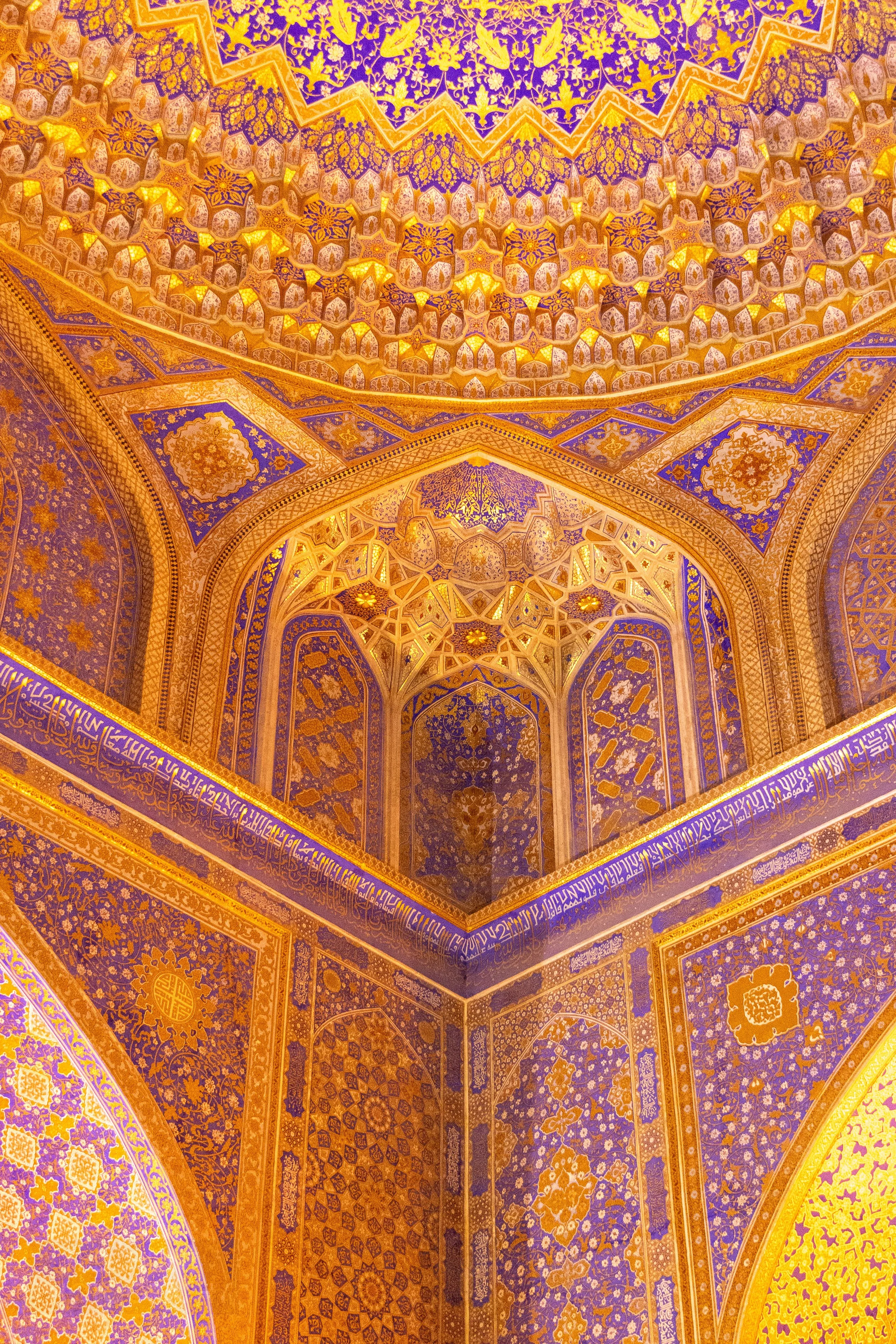 Interior of the dome at the Museum of the History of the Registan Complex featuring vibrant gold and blue paint, Registan, Samarkand, Uzbekistan.