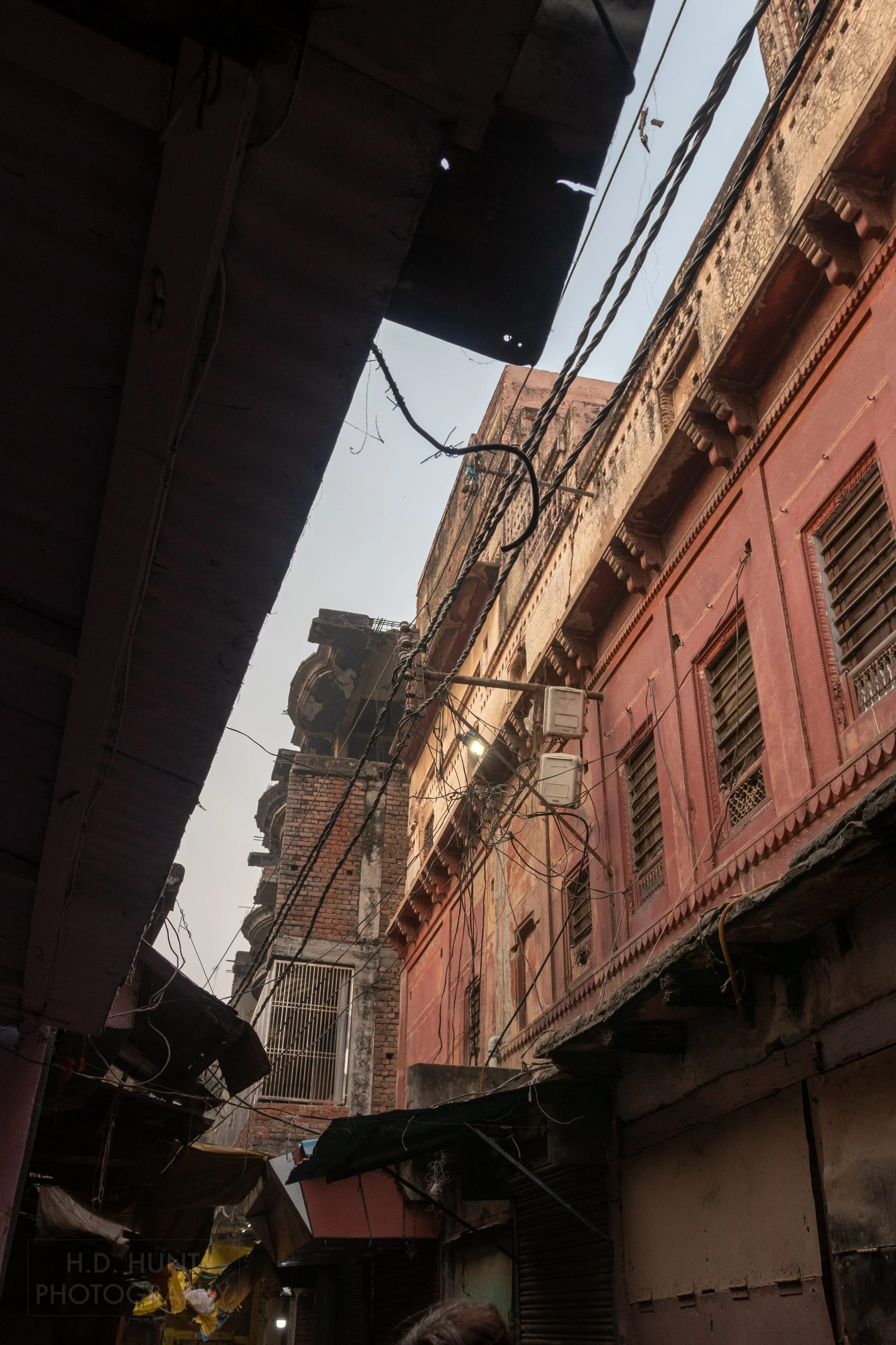 Electrical wires run above a narrow street in Varanasi, India.