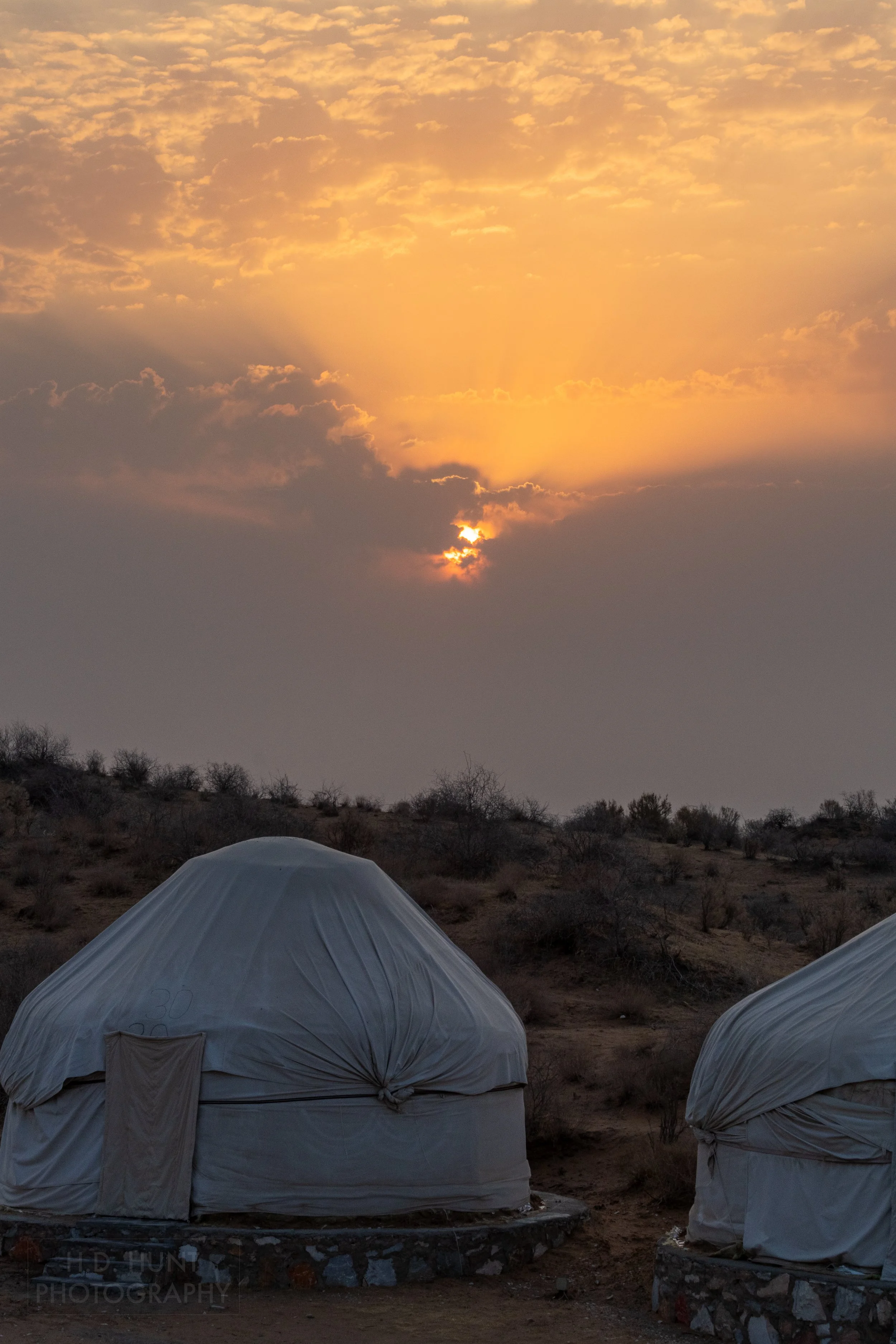 The sun rises behind two yurts, Yangikazgan, Uzbekistan.