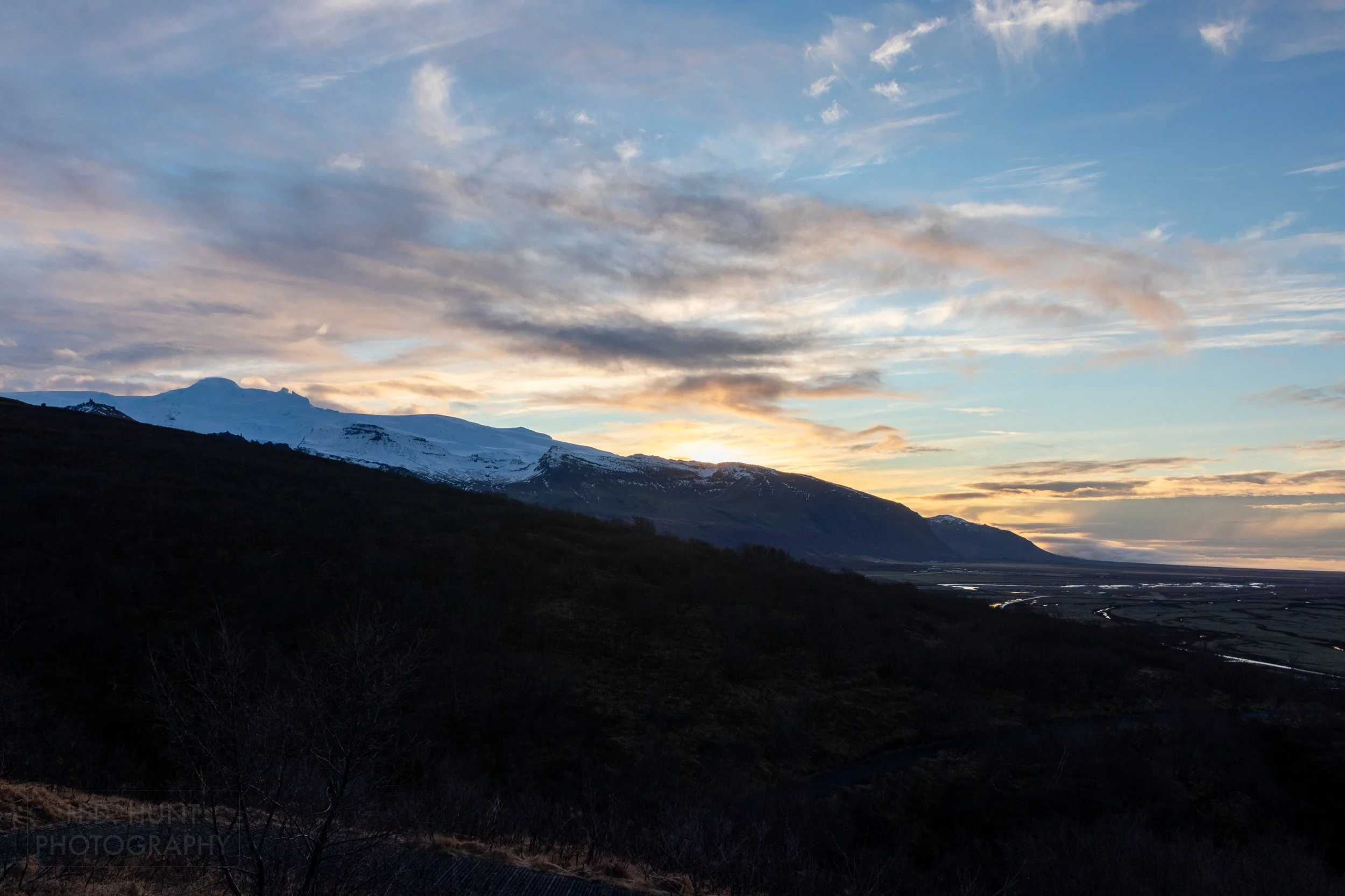 The sun rises above the Vatnajökull glacier far in the distance, Iceland.