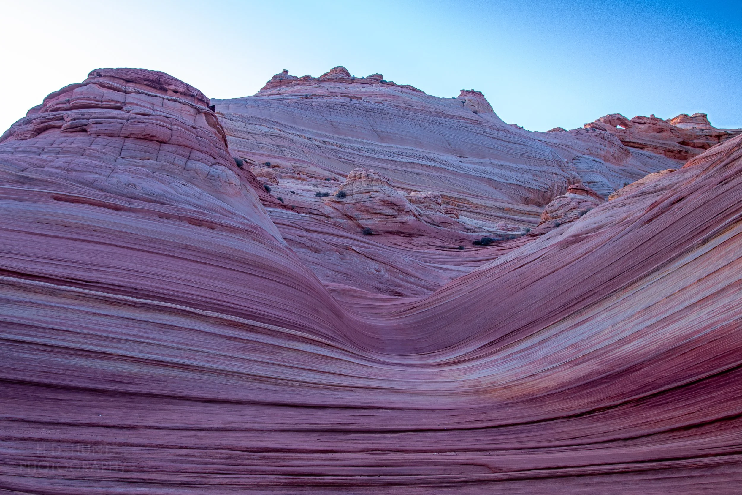 Deep pink and tan hues are seen in the layers of the The Wave, a sandstone rock formation in Coyote Buttes North, Paria Canyon-Vermilion Cliffs Wilderness, Arizona, United States.