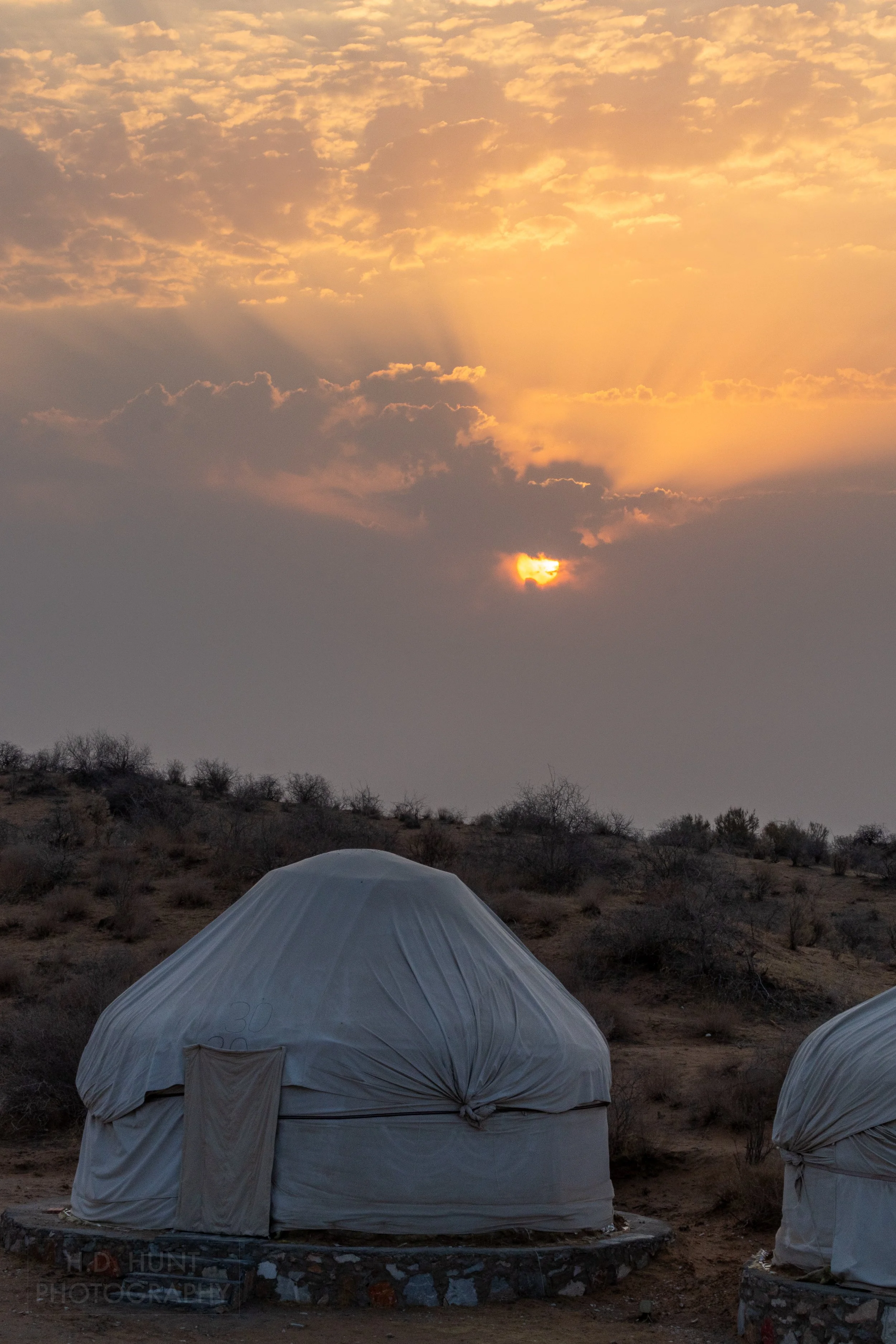 The sun rises behind two yurts, Yangikazgan, Uzbekistan.
