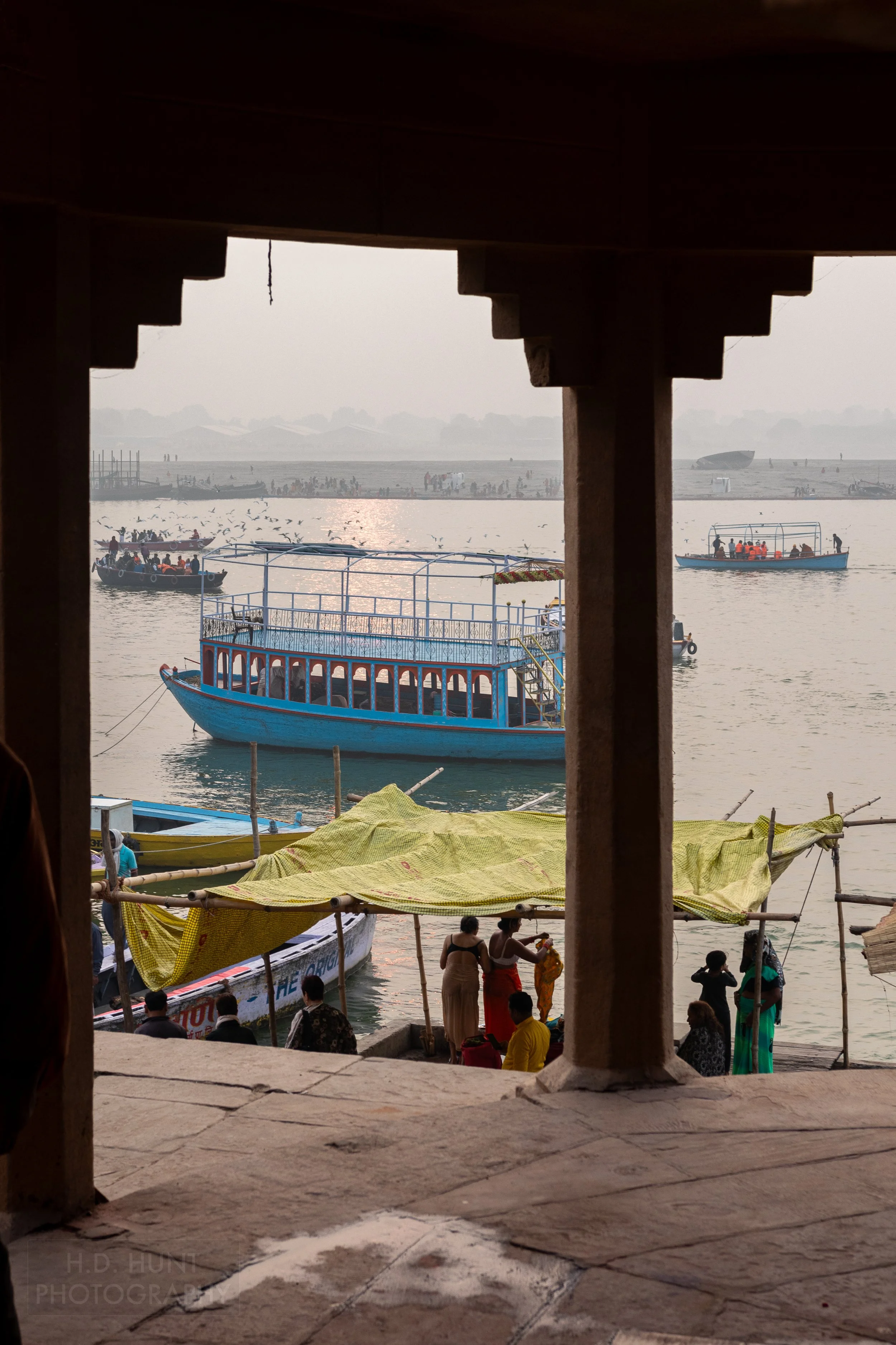 Boats are seen in the Ganges River through a stone archway, Varanasi, India.