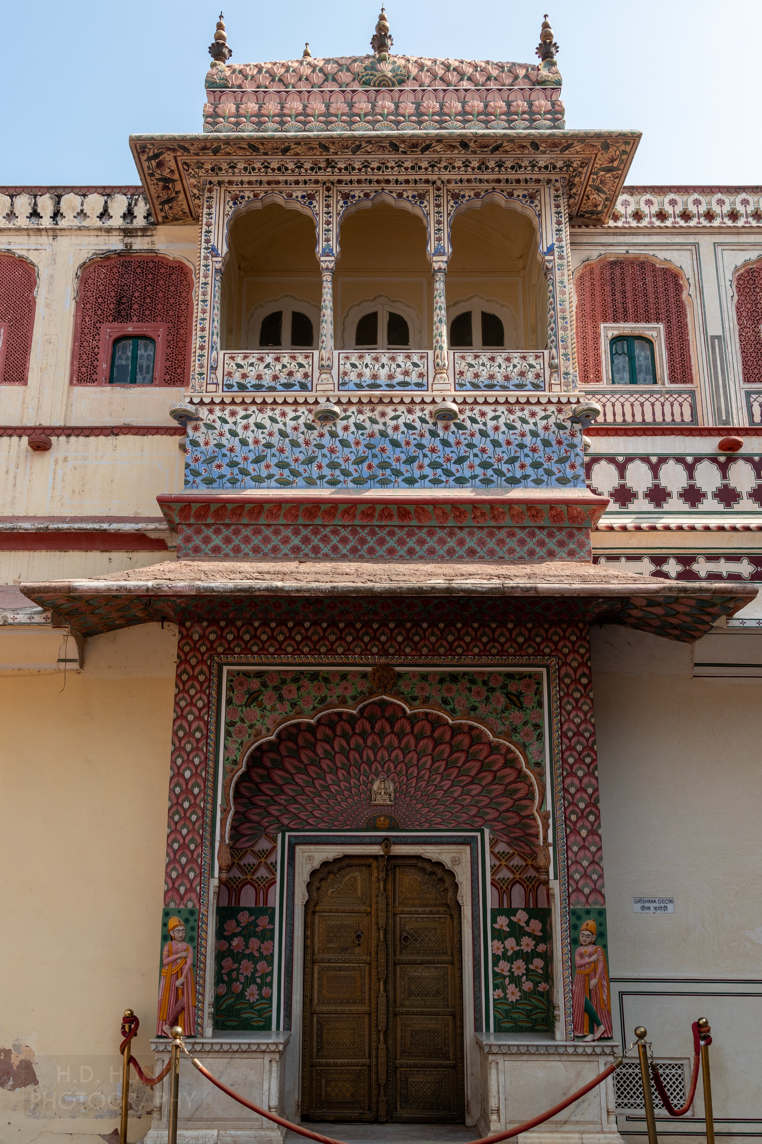 A colorful archway surrounds a wooden door, City Palace, Jaipur, India.