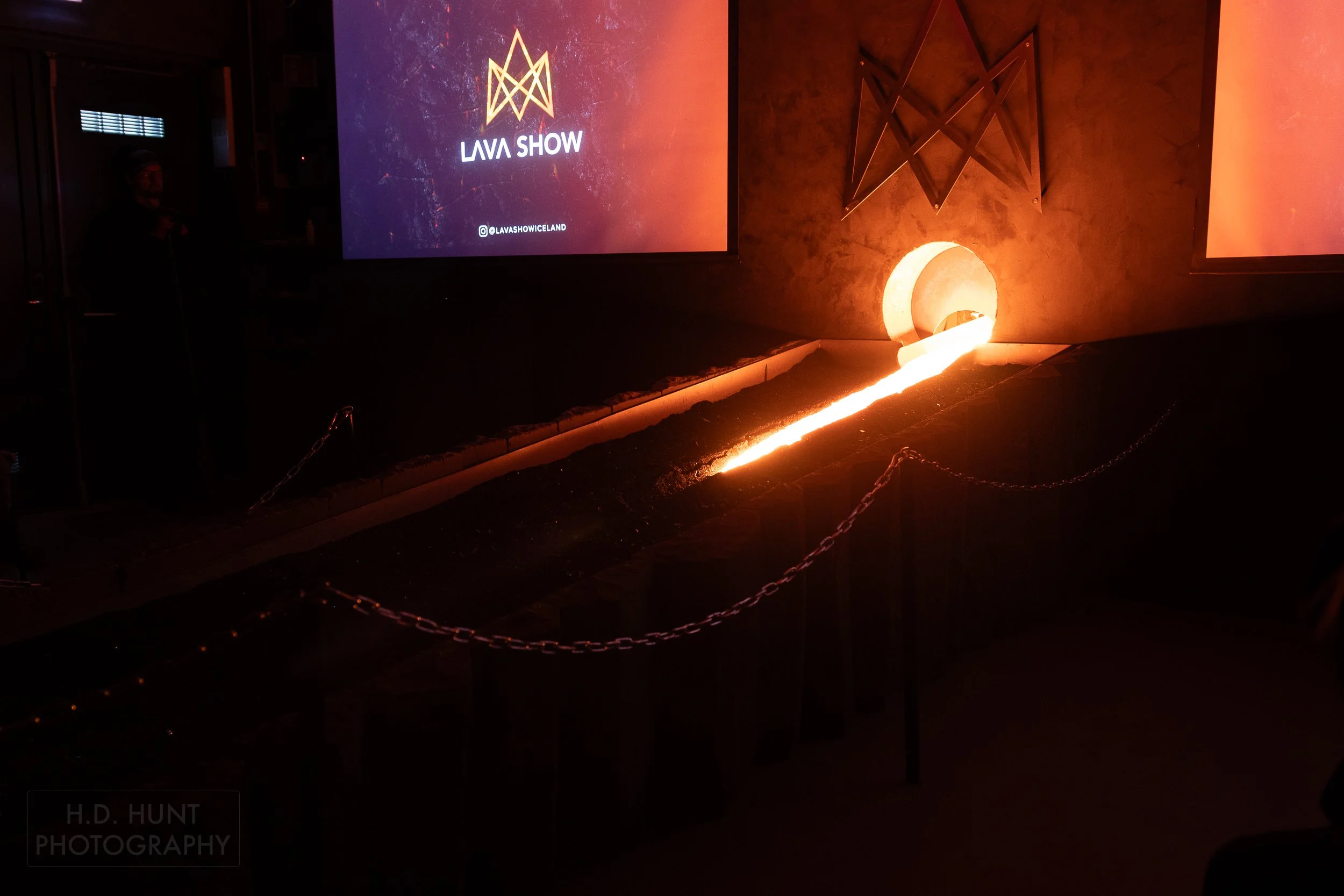 Bright orange lava runs down a black metal slope at the Lava Show, Vik i Myrdal, Iceland.
