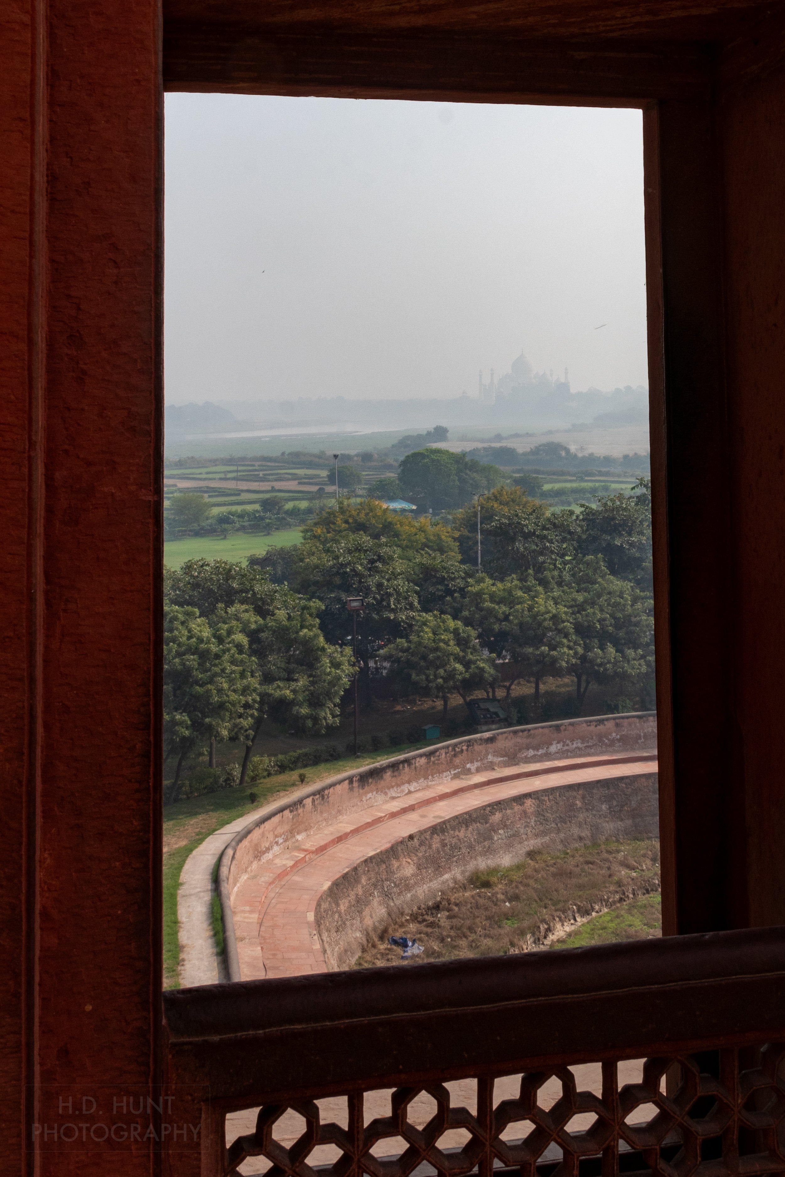 Far in the distance, the Taj Mahal can be seen through thick smog from Agra Fort, Agra, India.