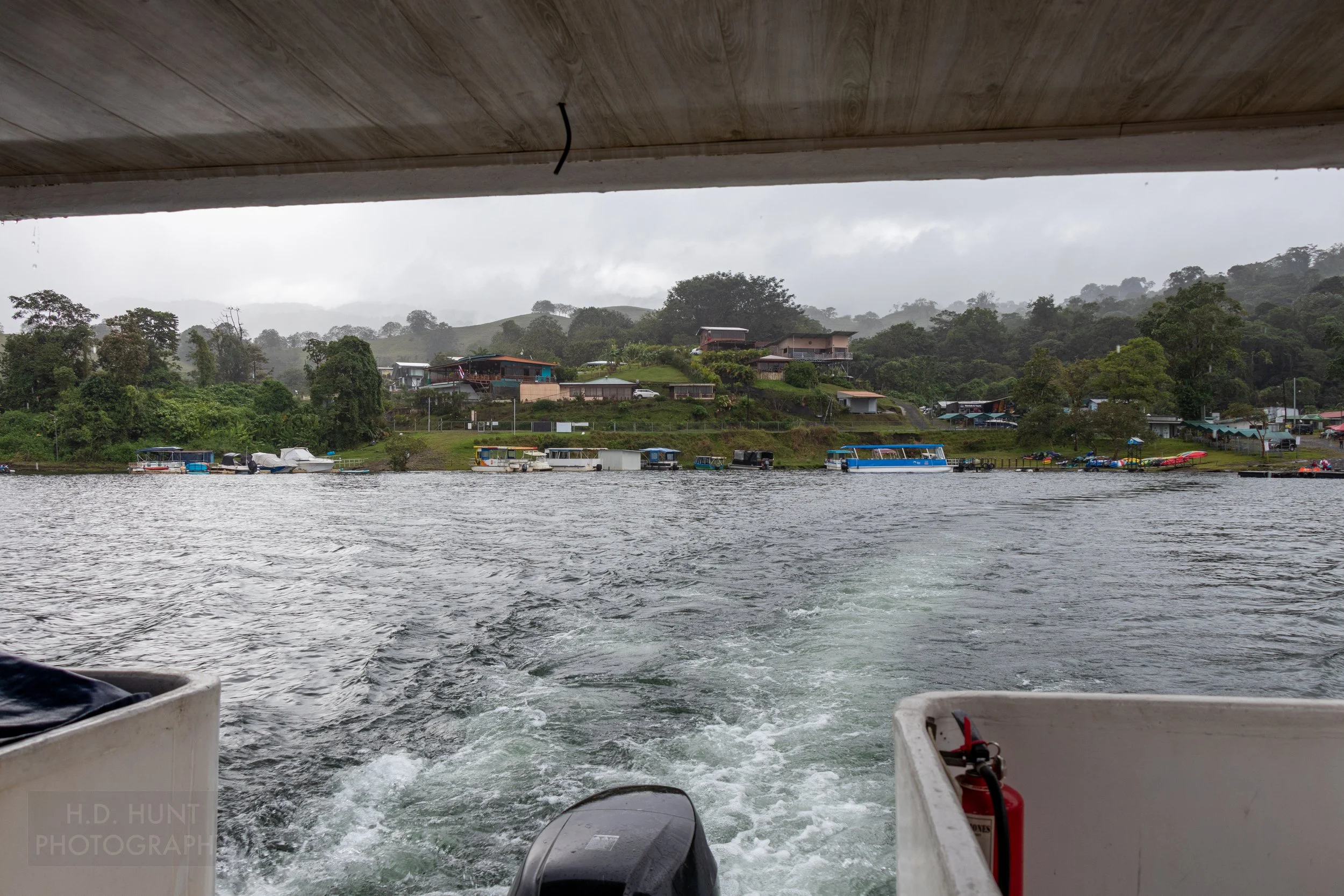 A boat pushes away from the shoreline of Lake Arenal, Costa Rica.