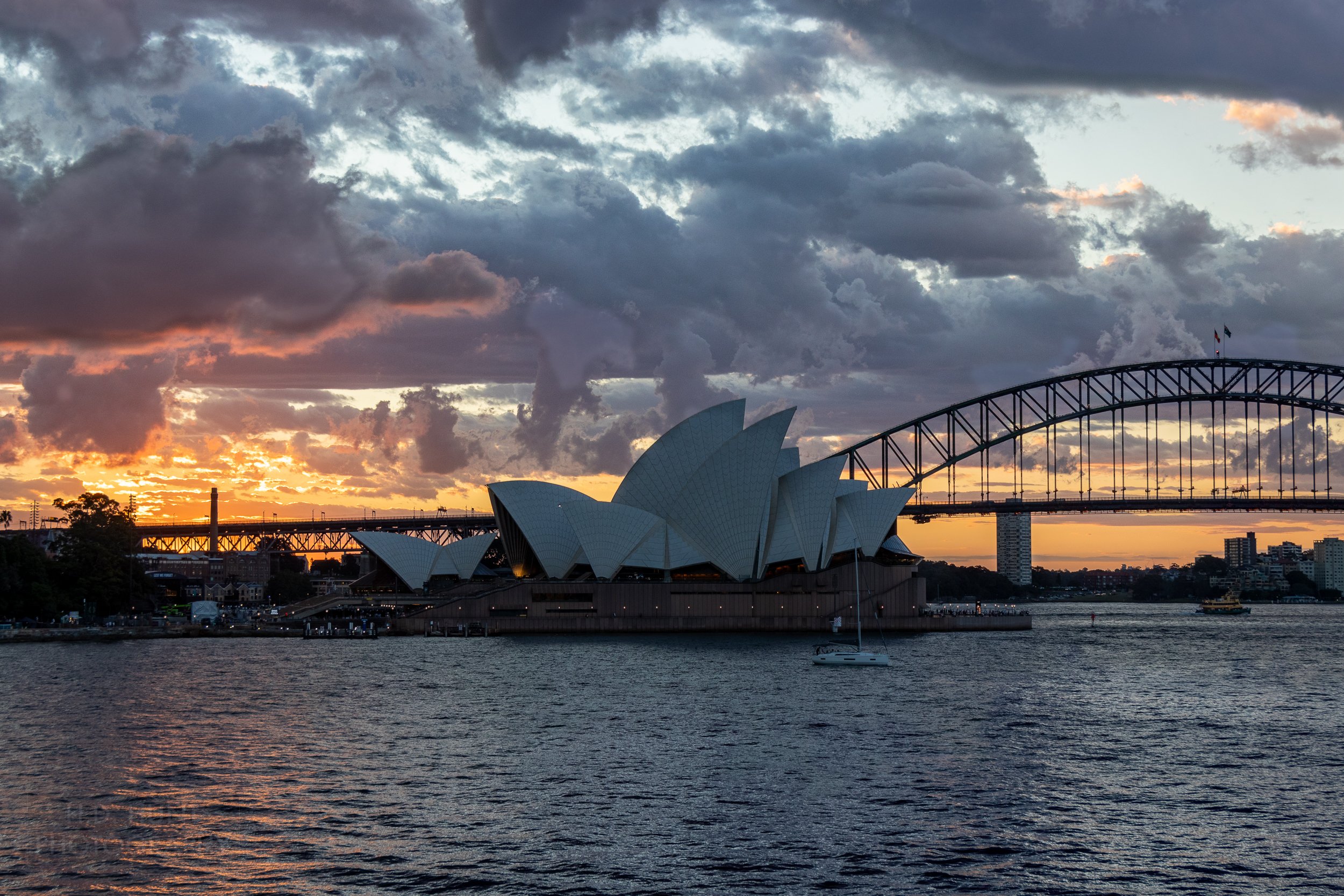 The sun sets behind the Sydney Opera House, Sydney, Australia.