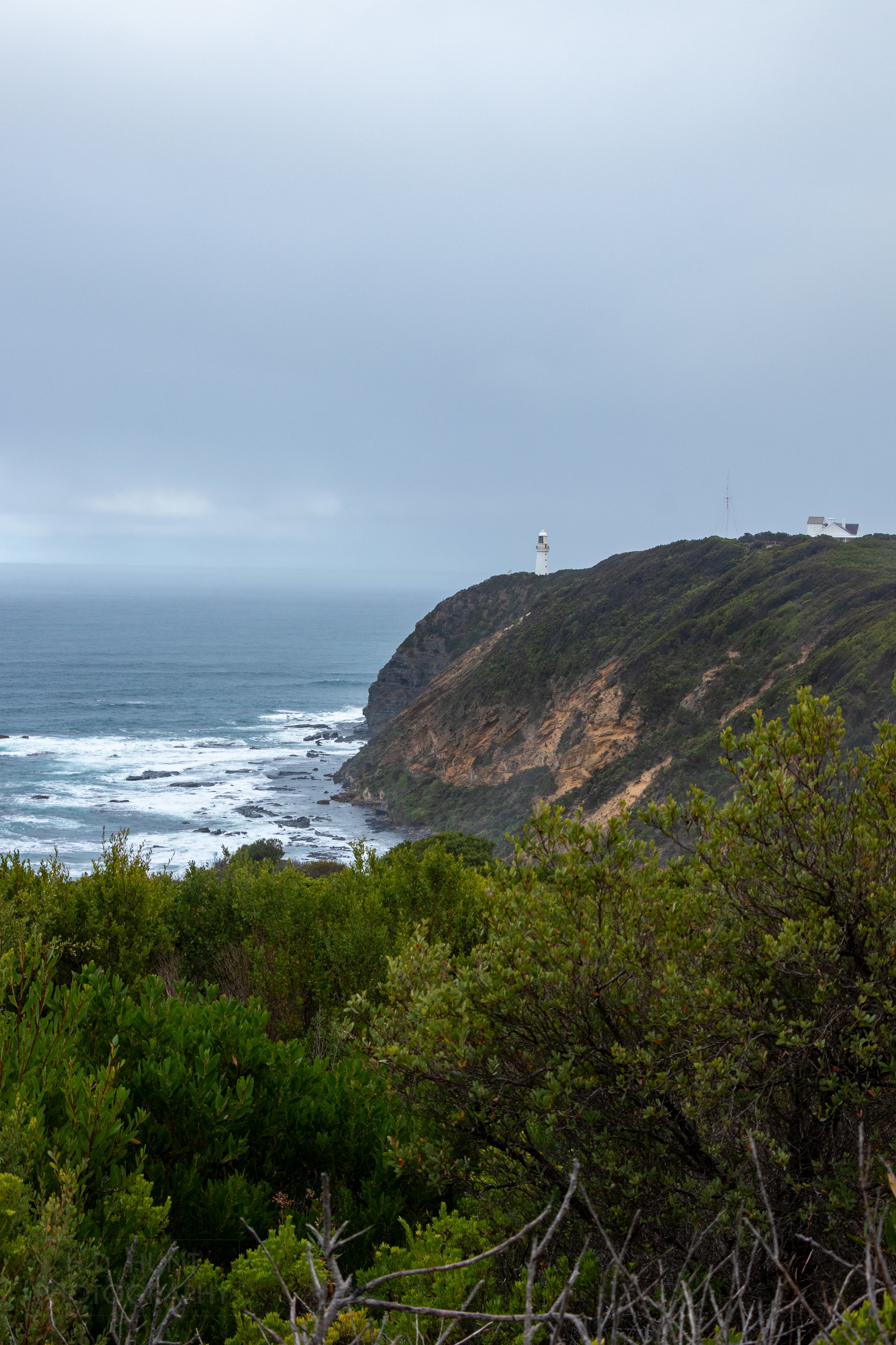 The white spire of the Cape Otway Lighthouse rises above Cape Otway, as seen from The Great Ocean Walk, Victoria, Australia.