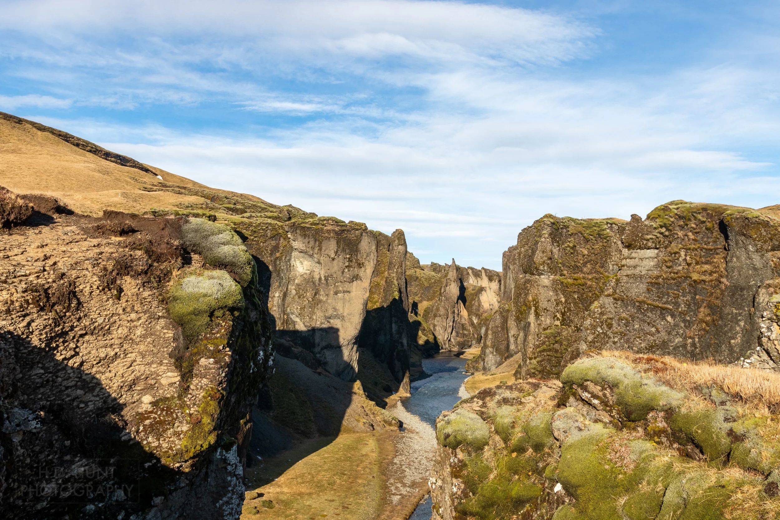 A river runs through a deep canyon at Fjaðrárgljúfur, Iceland.