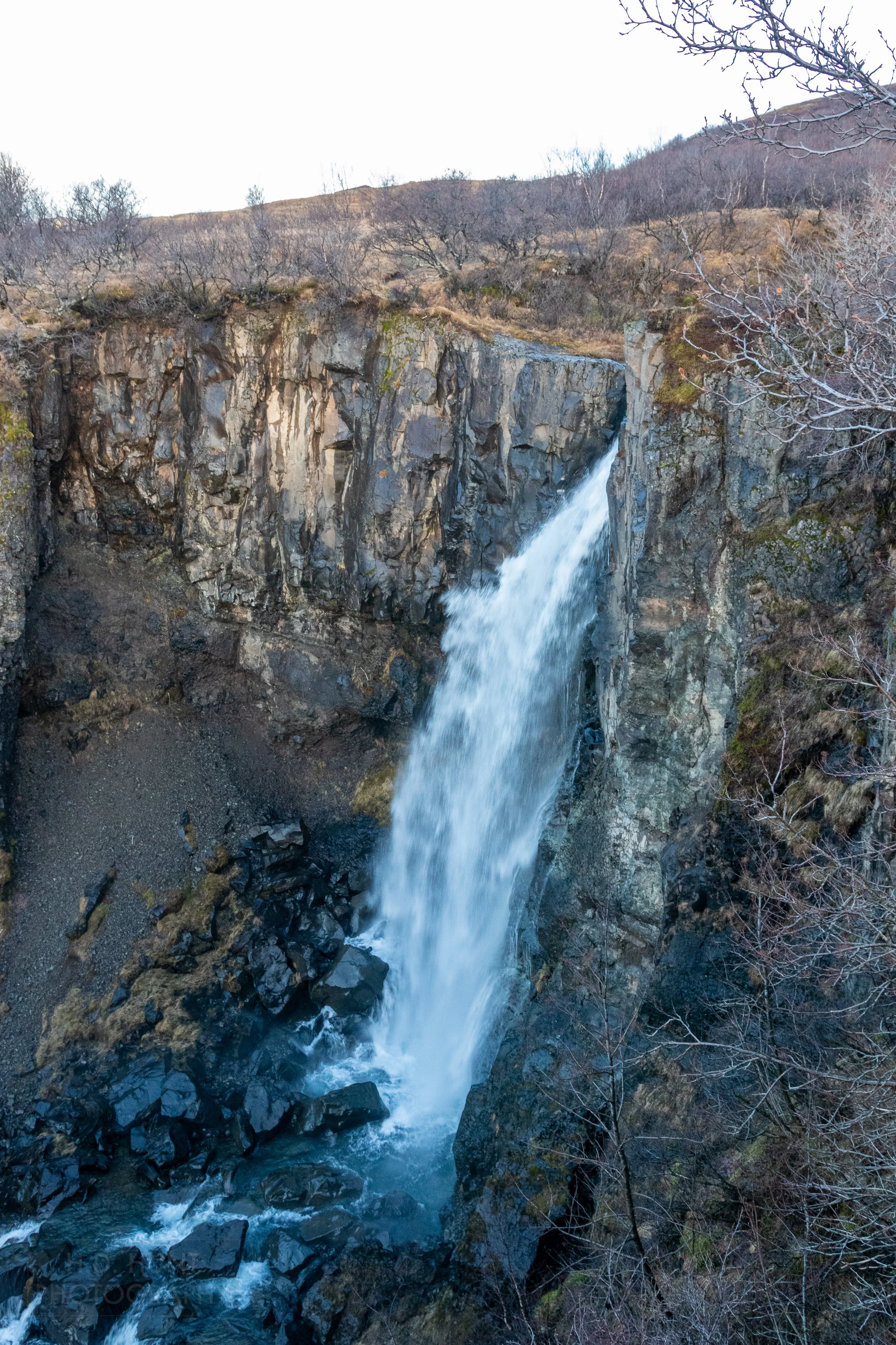 The Hundafoss waterfall cascades over a rocky cliff, Iceland.