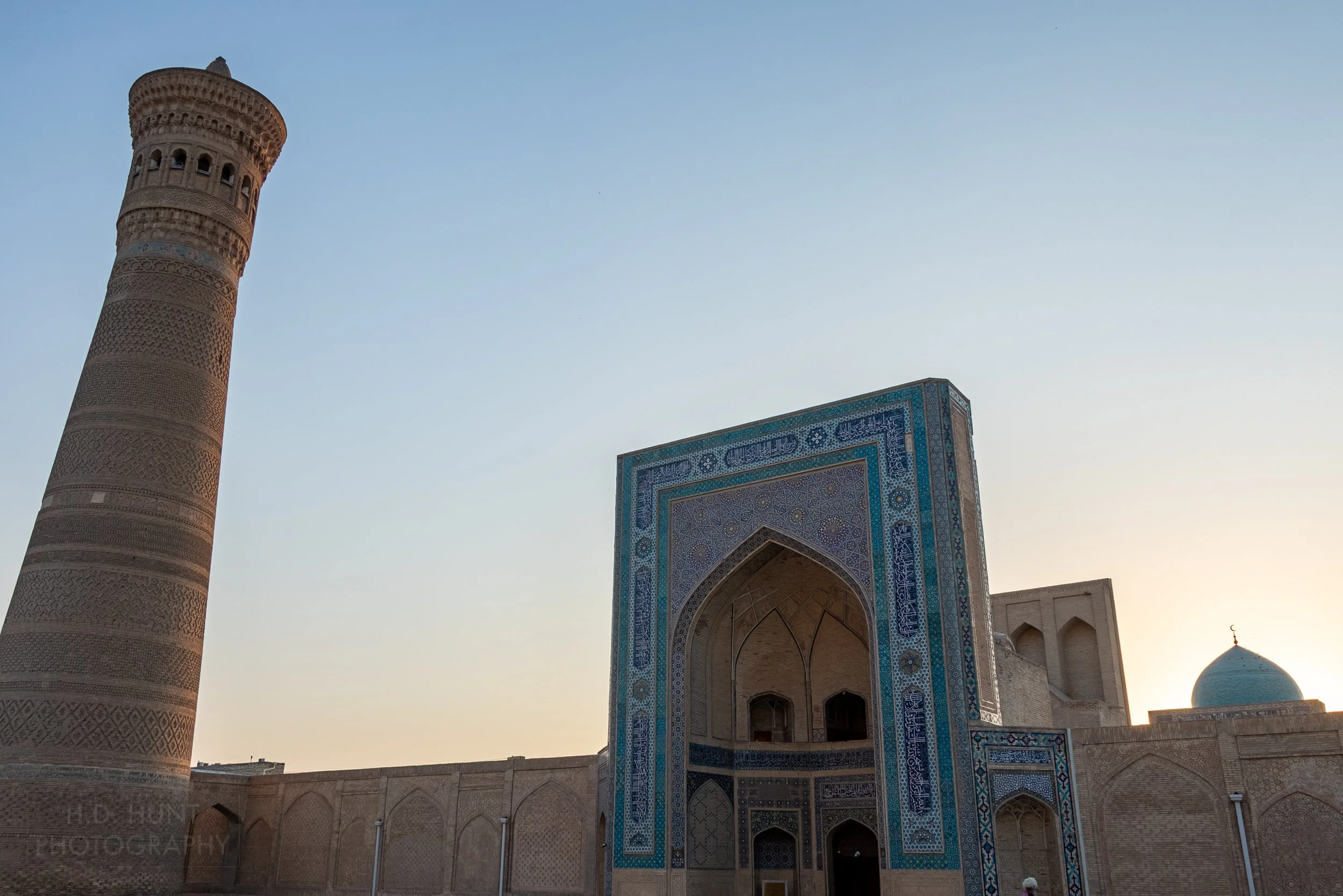 Eastern entrance of the Kalan Mosque complex with the Kalan Minaret to the left of frame, Bukhara, Uzbekistan.
