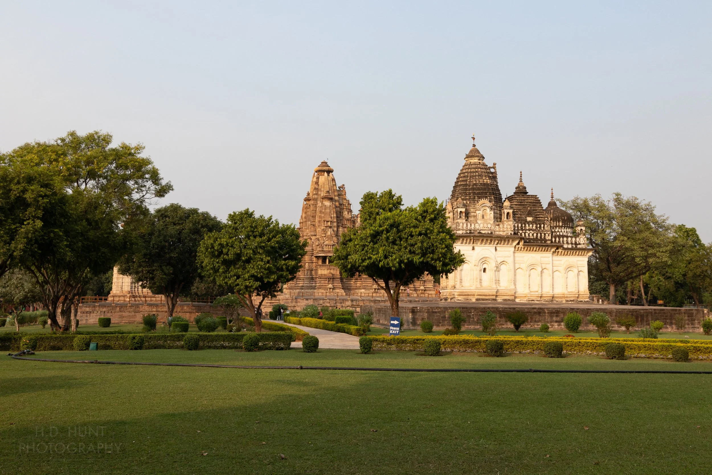 The Pratapeshwar Temple rises above manicured grass at the Khajuraho Group of Monuments, India.