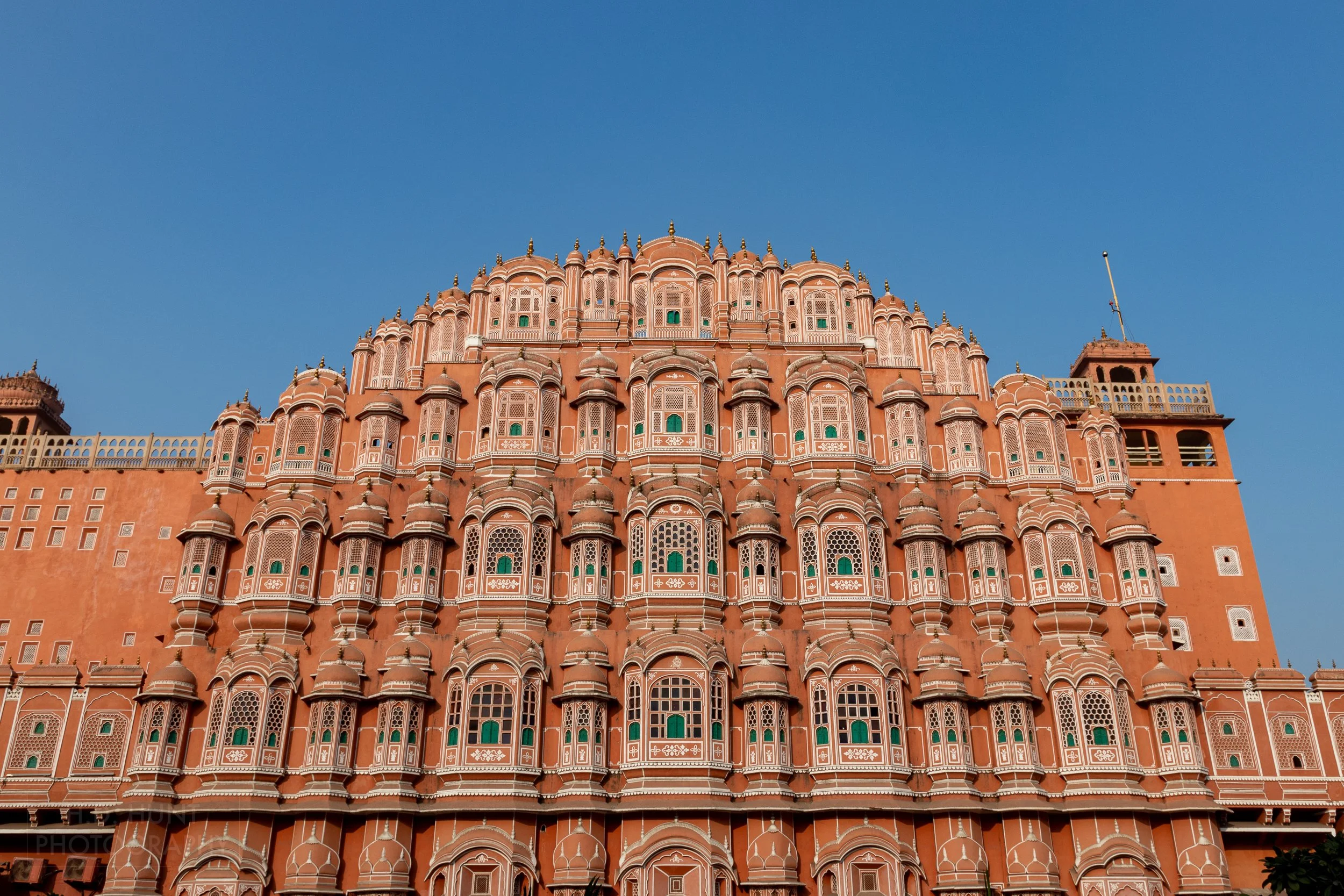 The pink and white multi-windowed facade of Hawa Mahal, Jaipur, India.