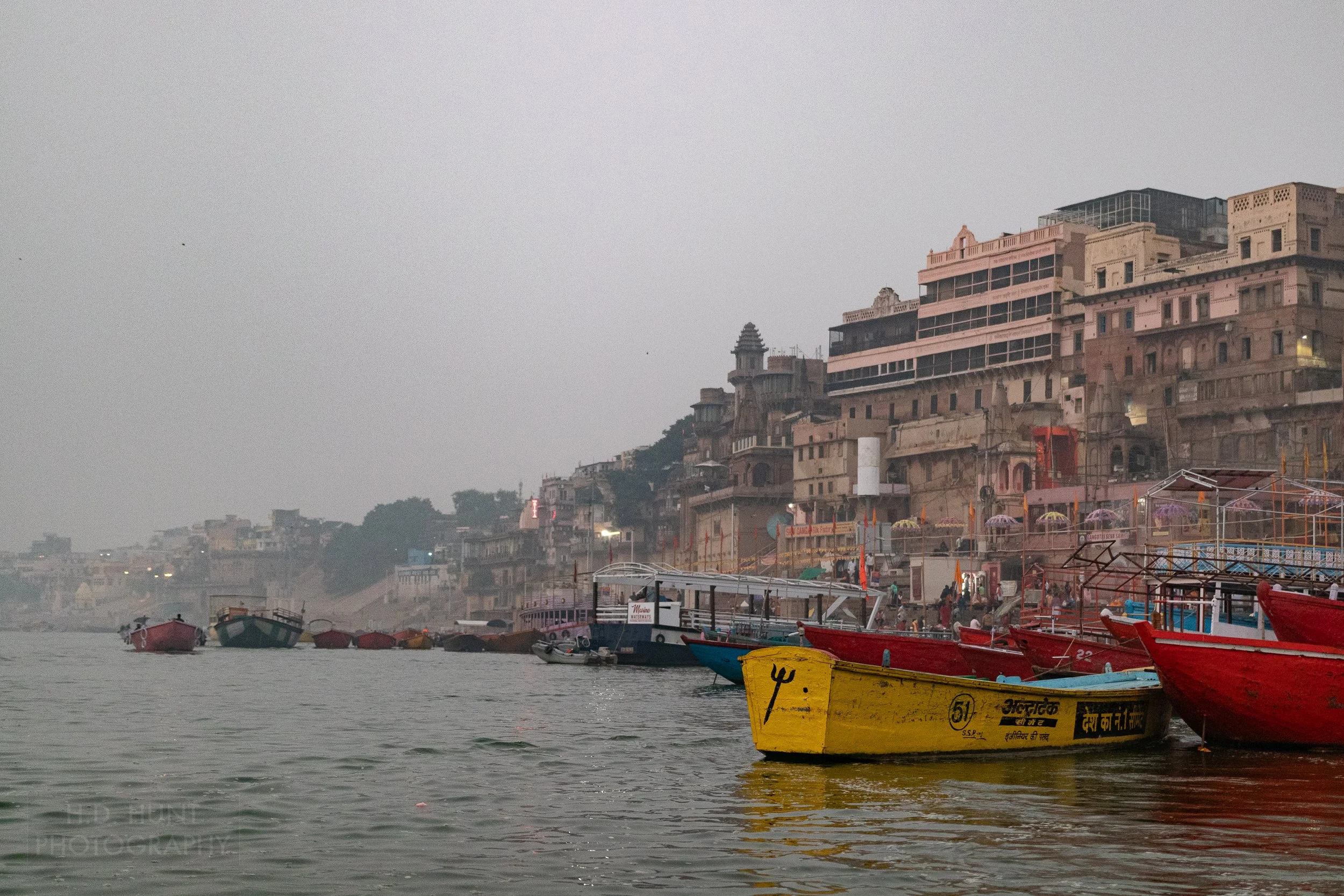 Multiple temple buildings are seen through thick smog along the Ganges River, Varanasi, India.