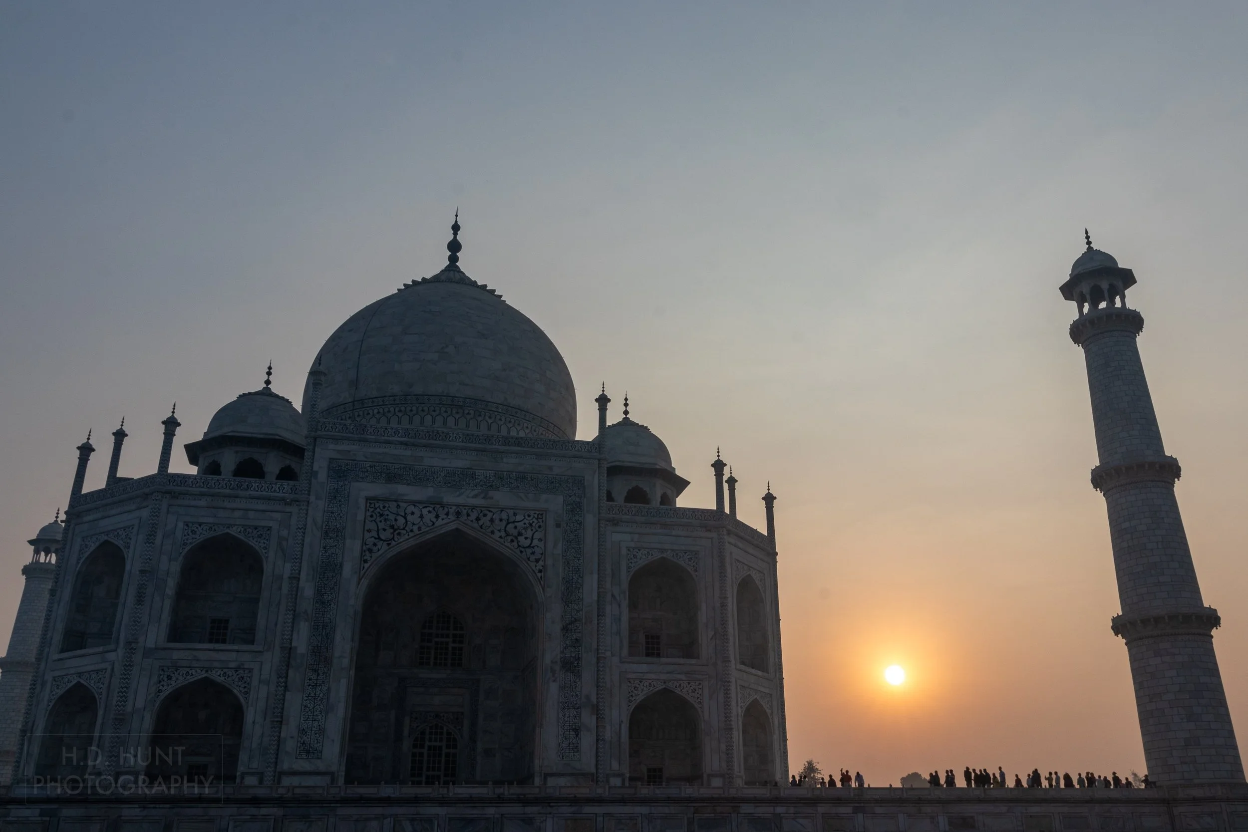 The sun rises behind a silhouetted Taj Mahal, Agra, India.