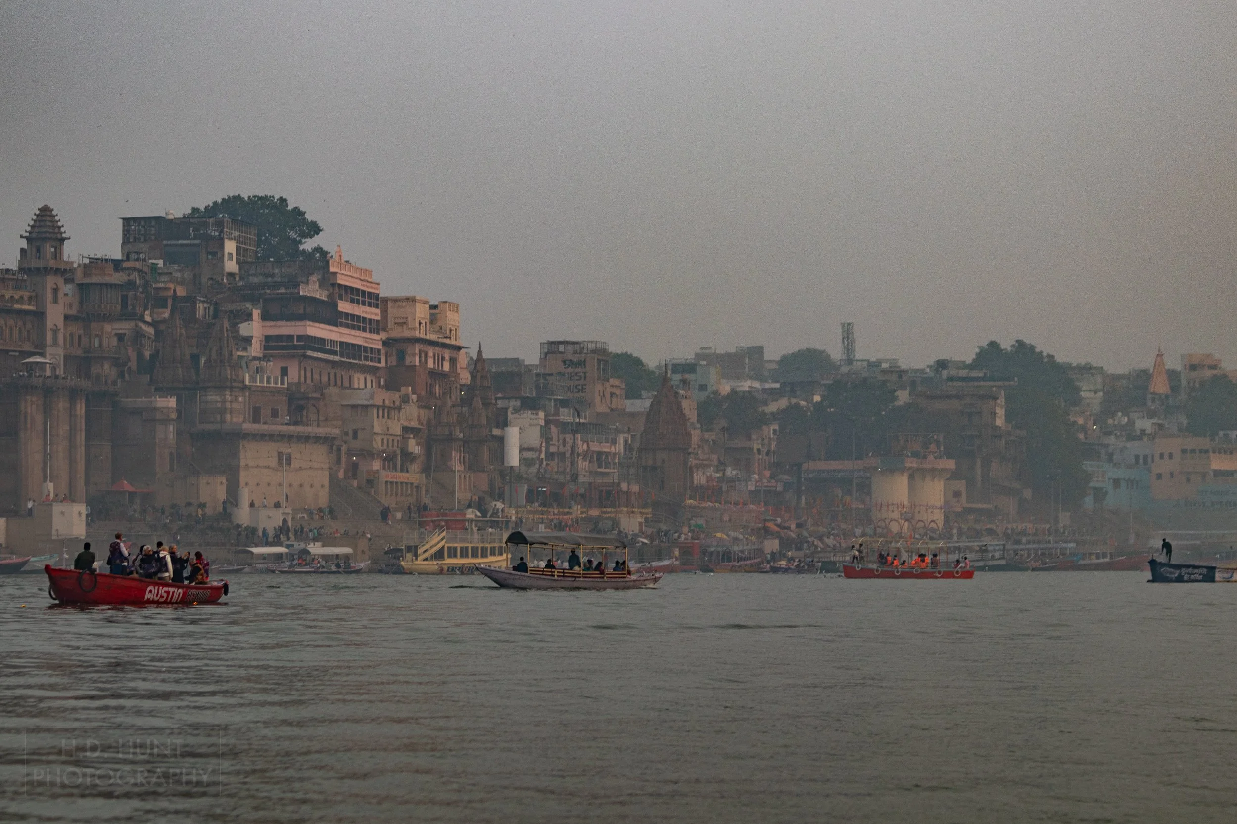 Boats are seen in the Ganges River in front of a hazy Varanasi, India.
