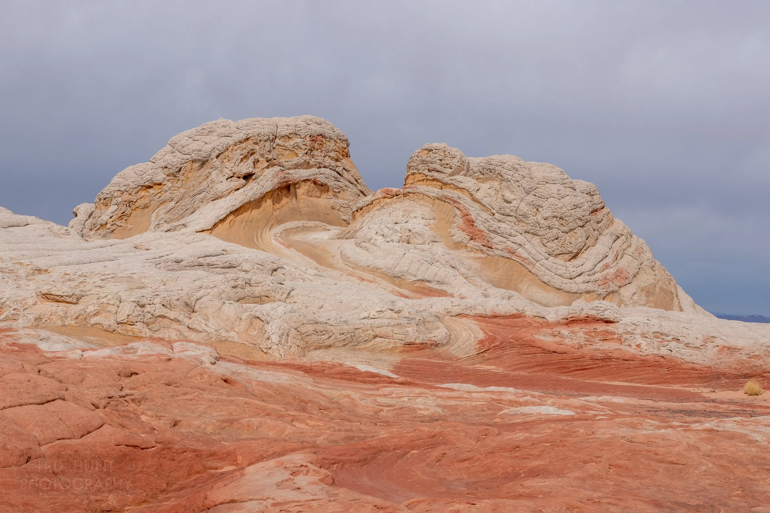A heavily deformed and folded striped white and tan rock mound in White Pocket, Vermillion Cliffs National Monument, Arizona, United States.