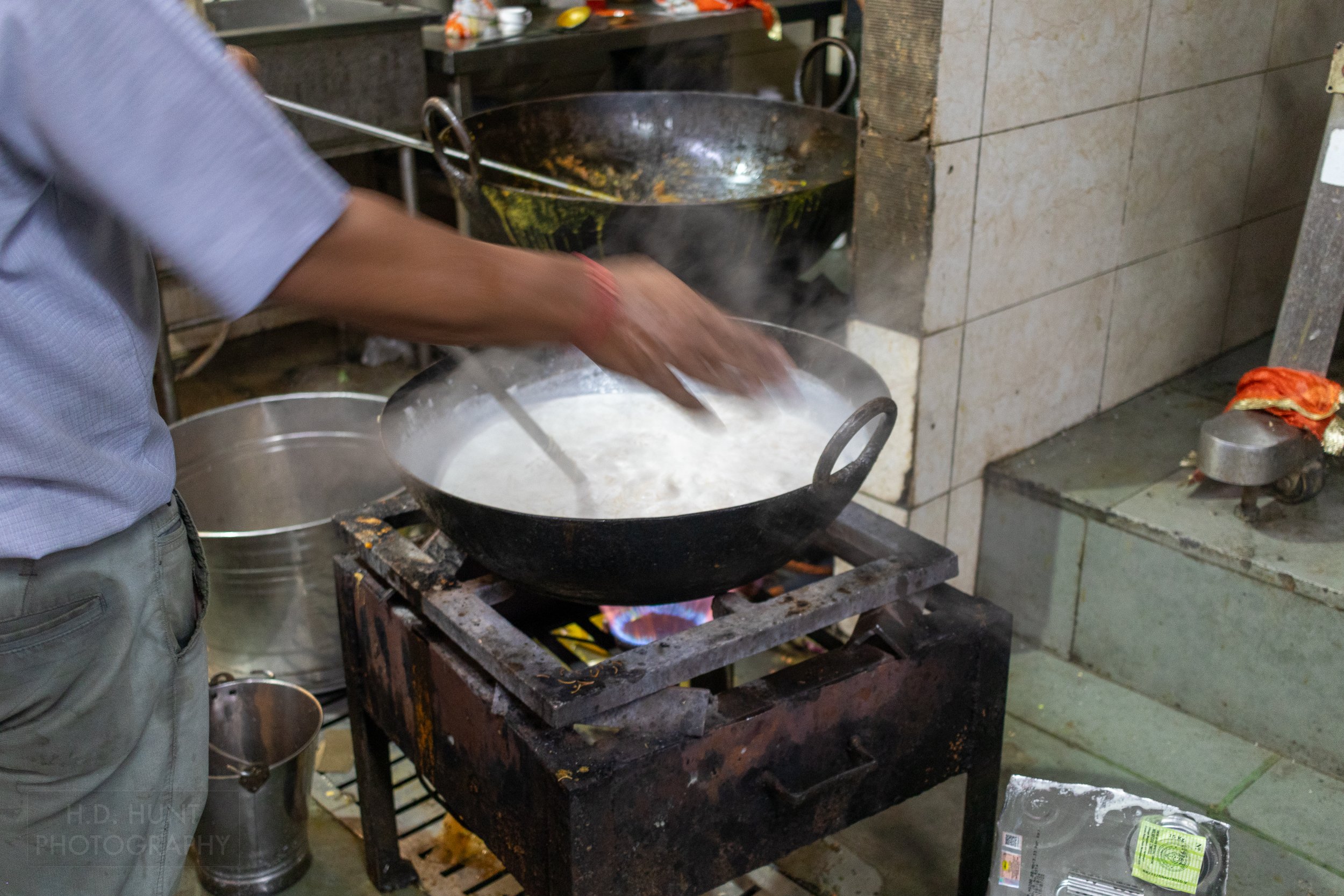 Food is prepared in a steel wok inside the Gurdwara Bangla Sahib, Delhi, India.