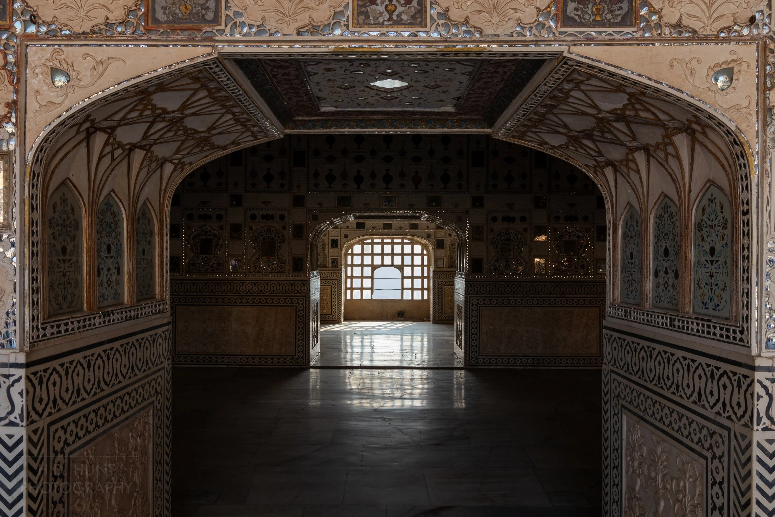 A dark corridor featuring multiple mirrors, Amber Fort, Amer, India.