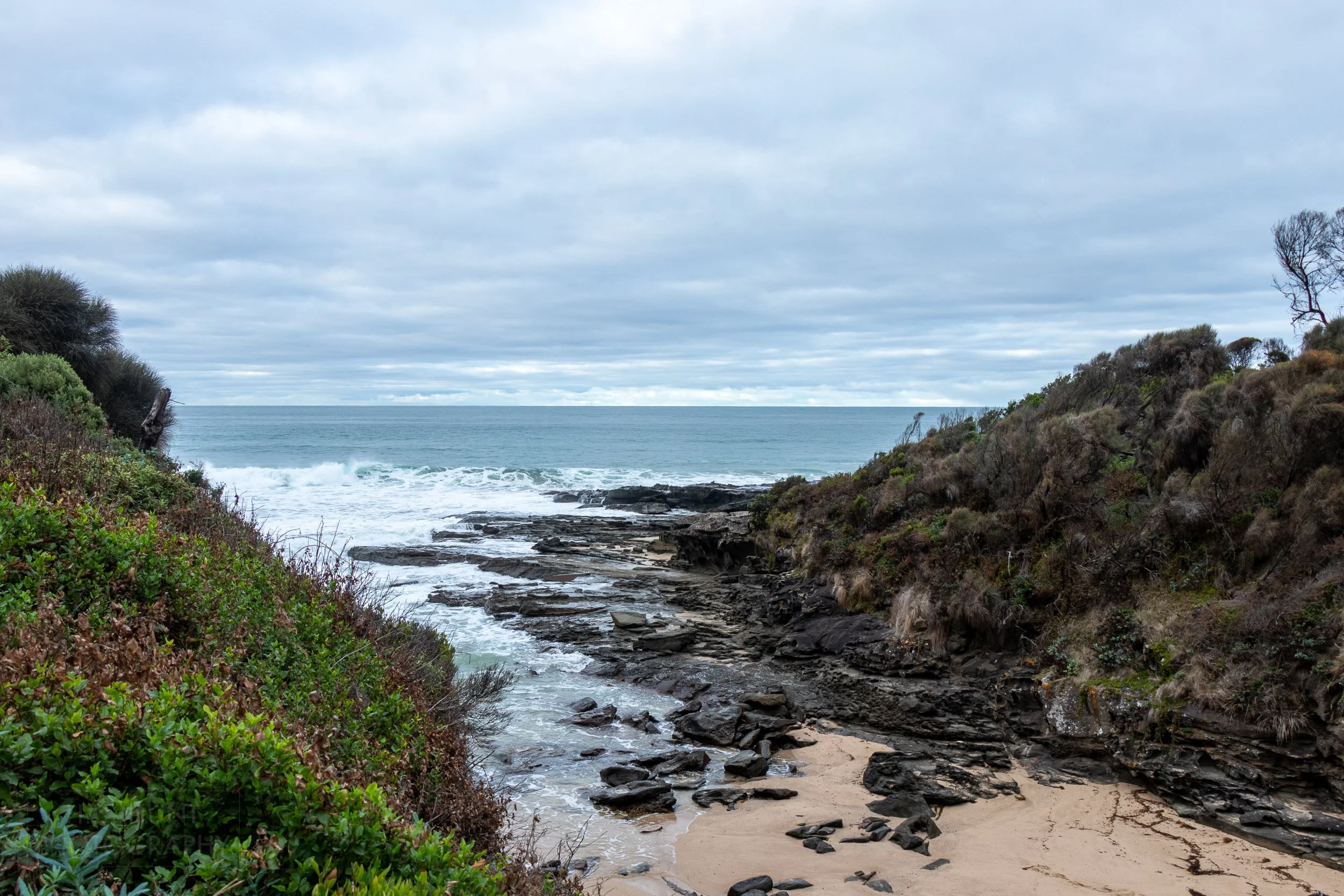 Waves from the Southern Ocean crash against rocks in a small inlet along The Great Ocean Walk, Victoria, Australia.
