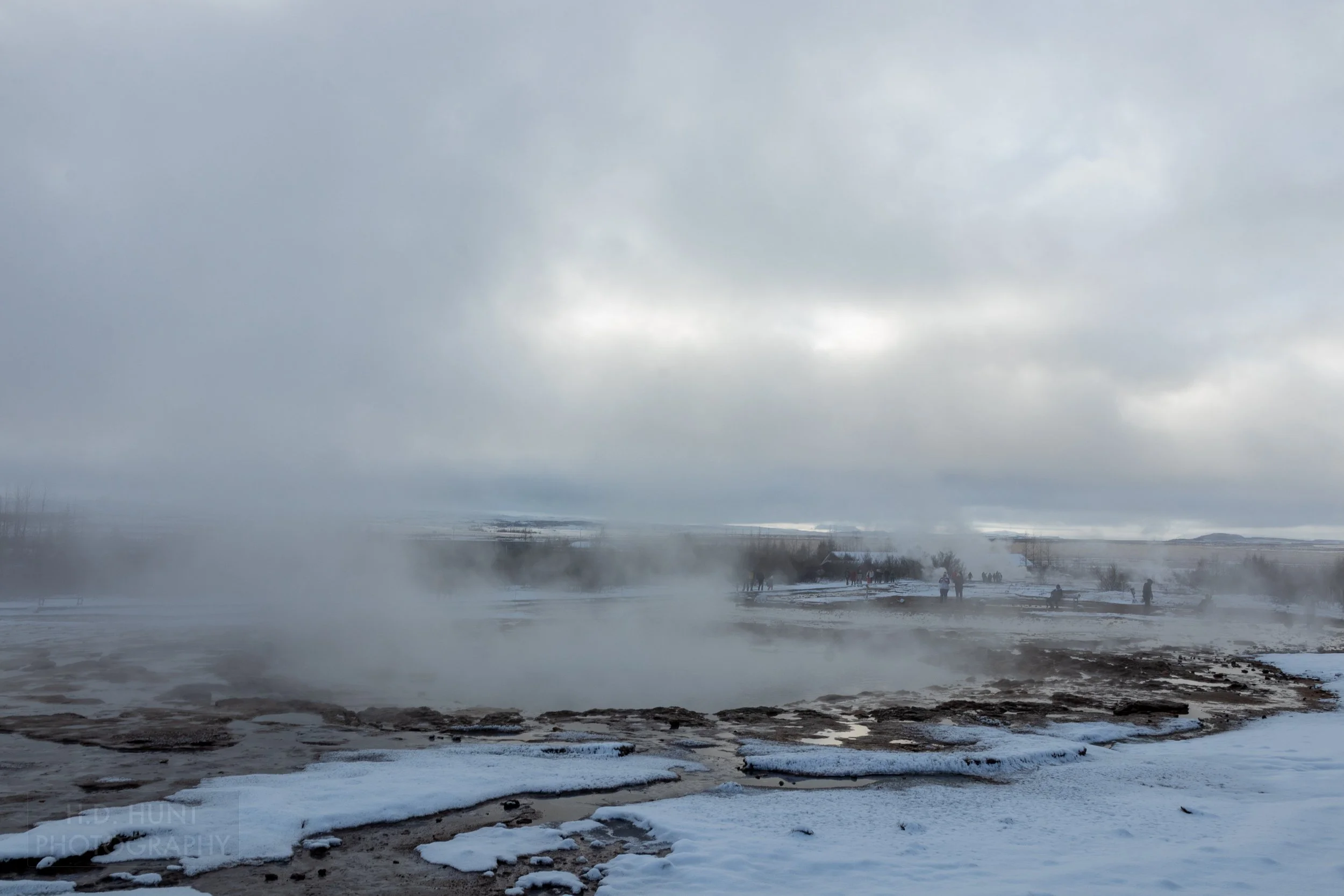 Steam rises from a geothermal vent in the ground at Haukadalur, Iceland.