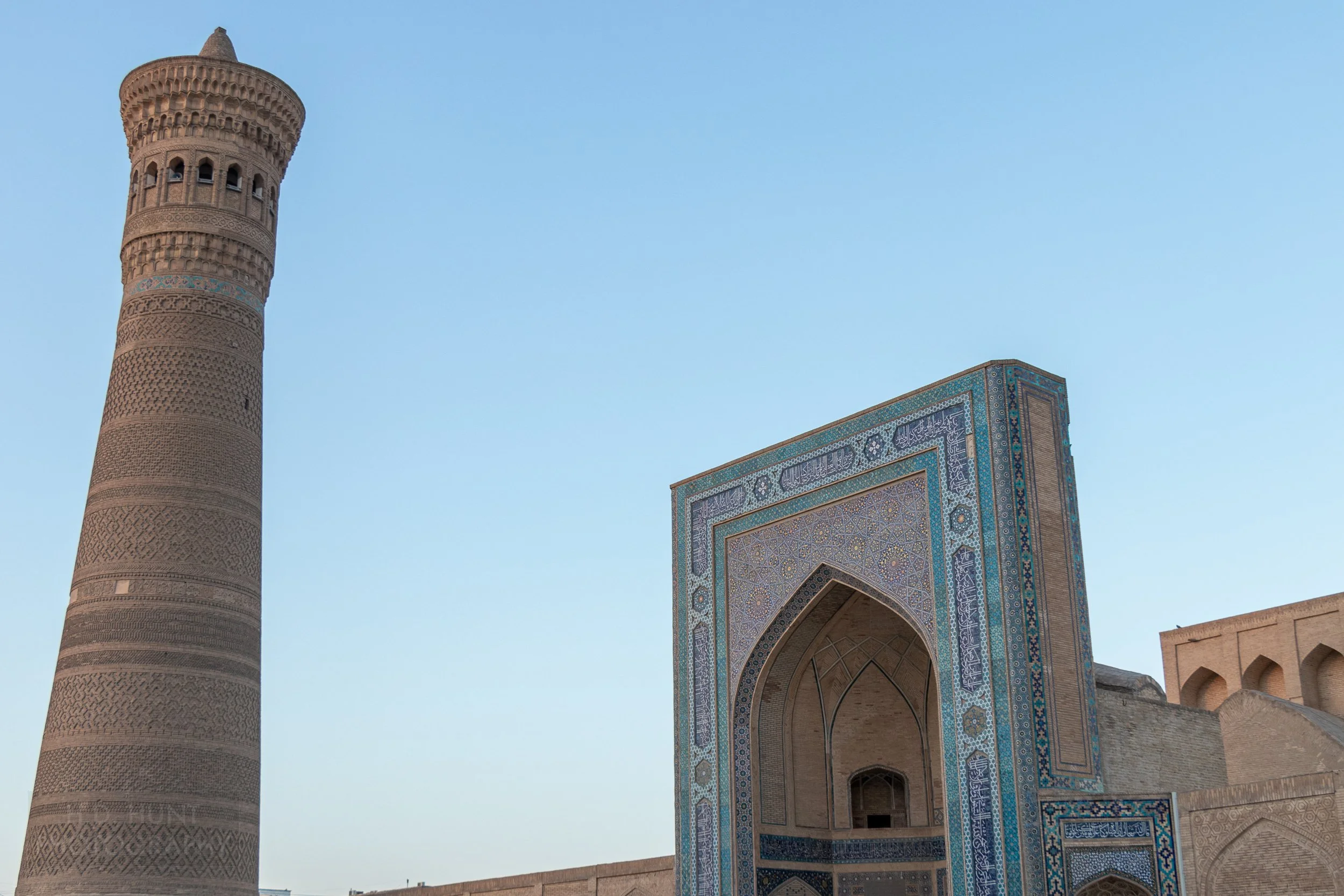 The sun rises on the facade of Kalan Mosque and the Kalan Minaret, Bukhara, Uzbekistan.