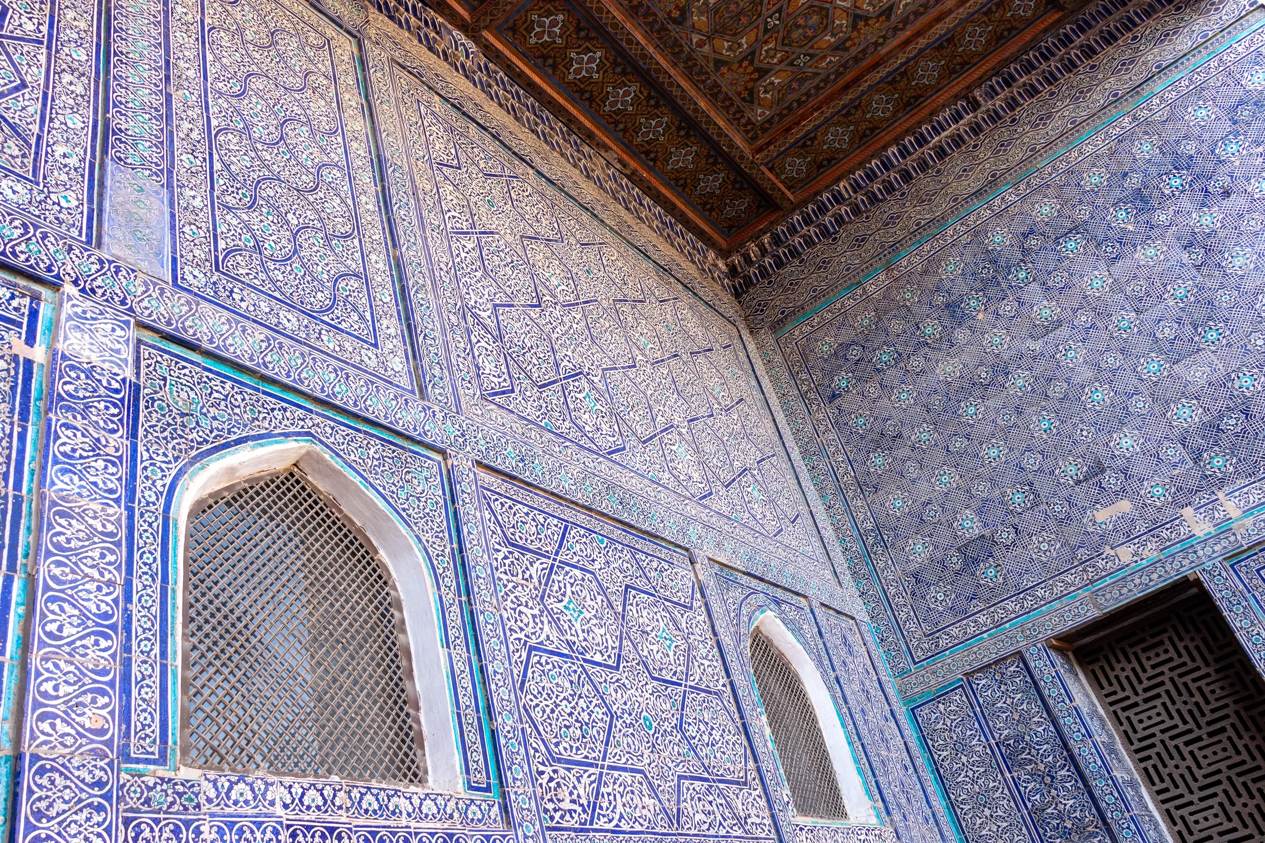 Intricate blue and white tiles and metal screens are seen on a facade in the Reception Courtyard of the Kuhna Ark, Khiva, Uzbekistan.