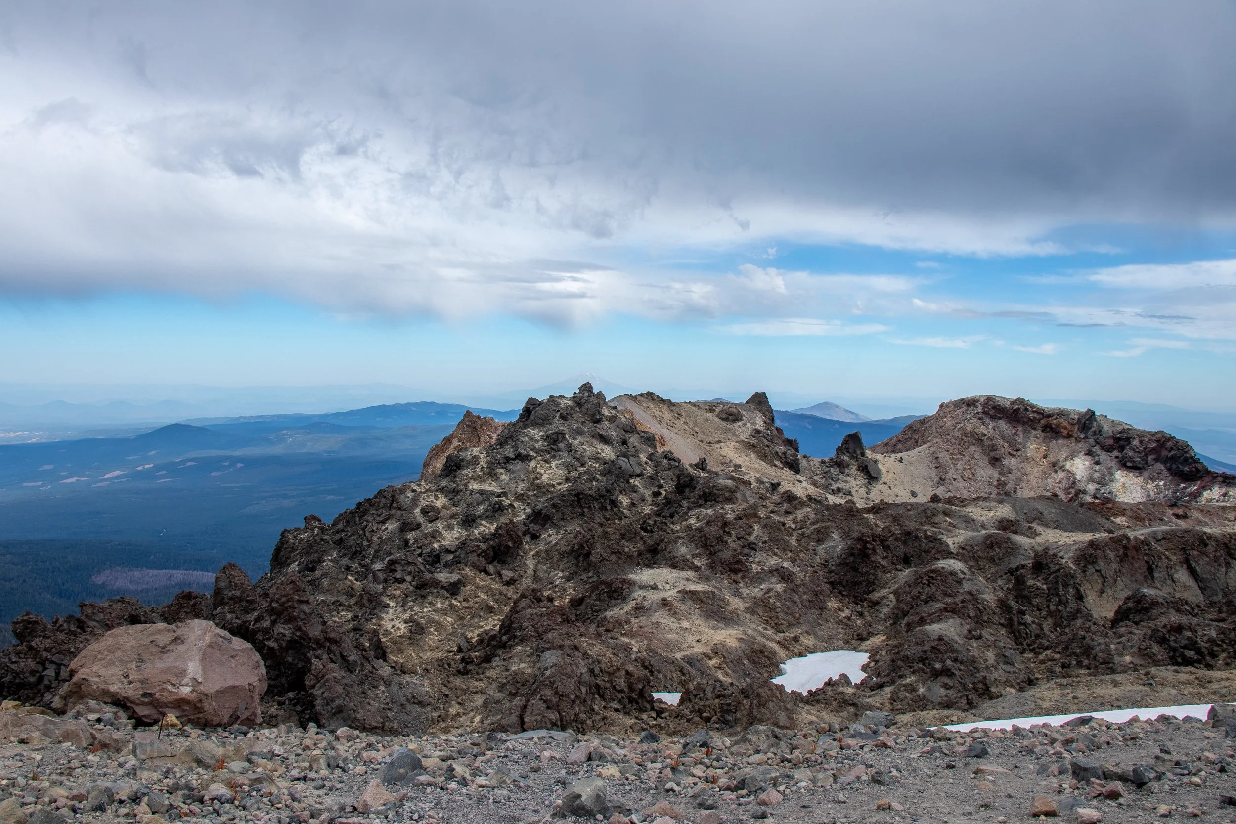 Beneath thick grey clouds can be seen the rocky peak of Lassen Peak, Lassen Volcanic National Park, California, United States.