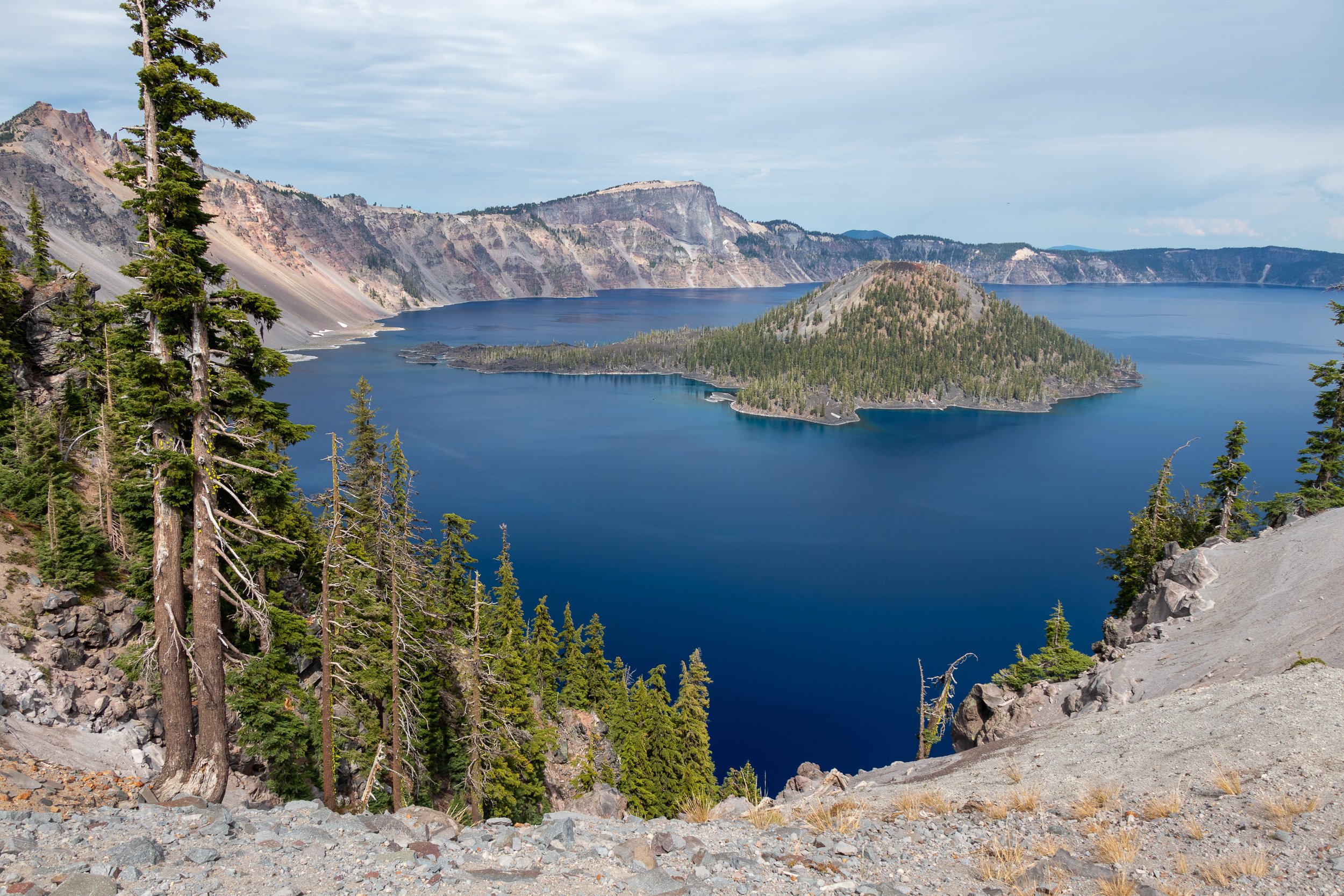 A view of the blue waters of Crater Lake with Wizard Island prominently featured in the middle of the photograph, Crater Lake National Park, Oregon, United States.