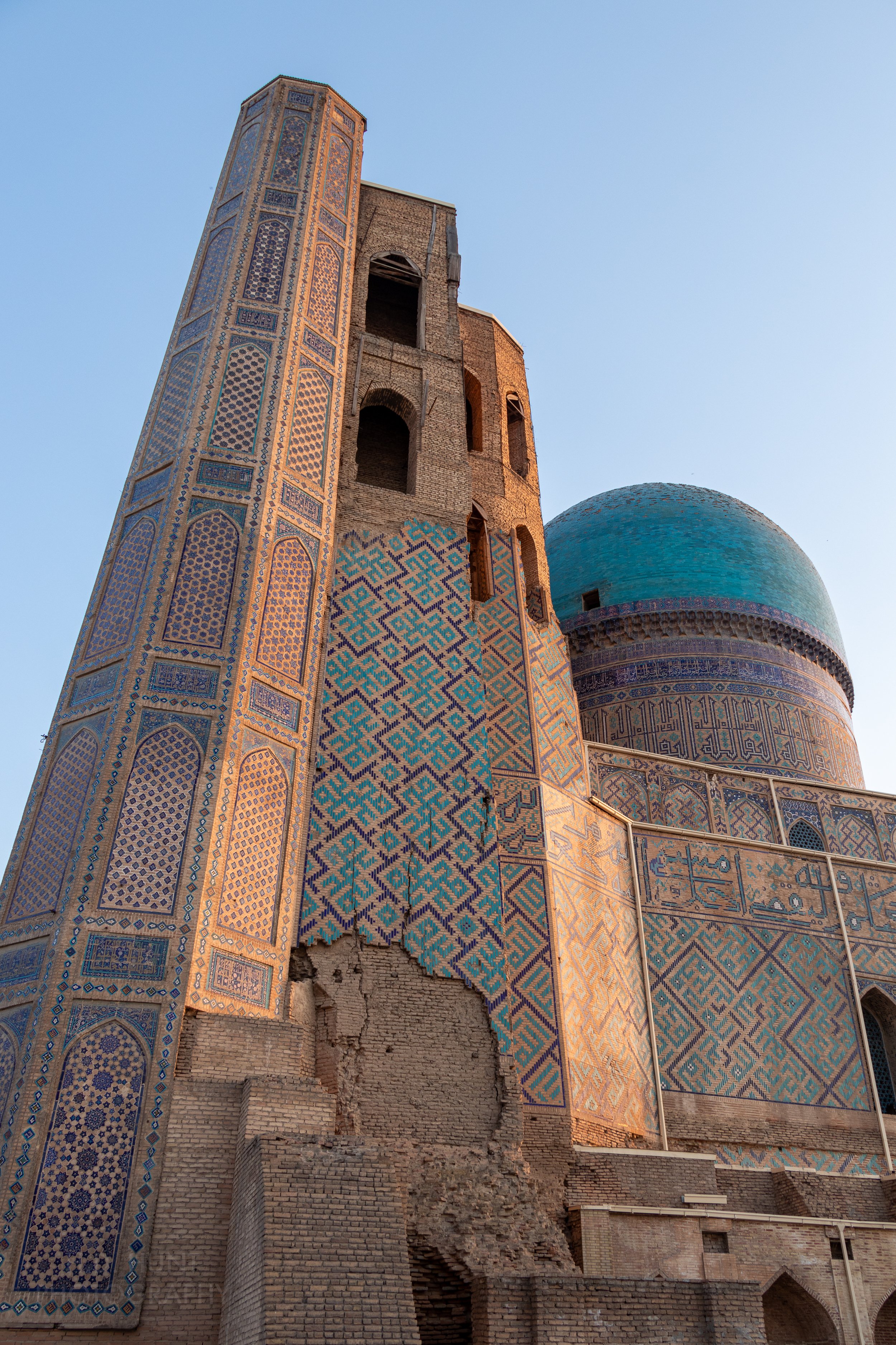 A partially damaged tower and blue-colored dome at the Bibi-Khanym Mosque, Samarkand, Uzbekistan.
