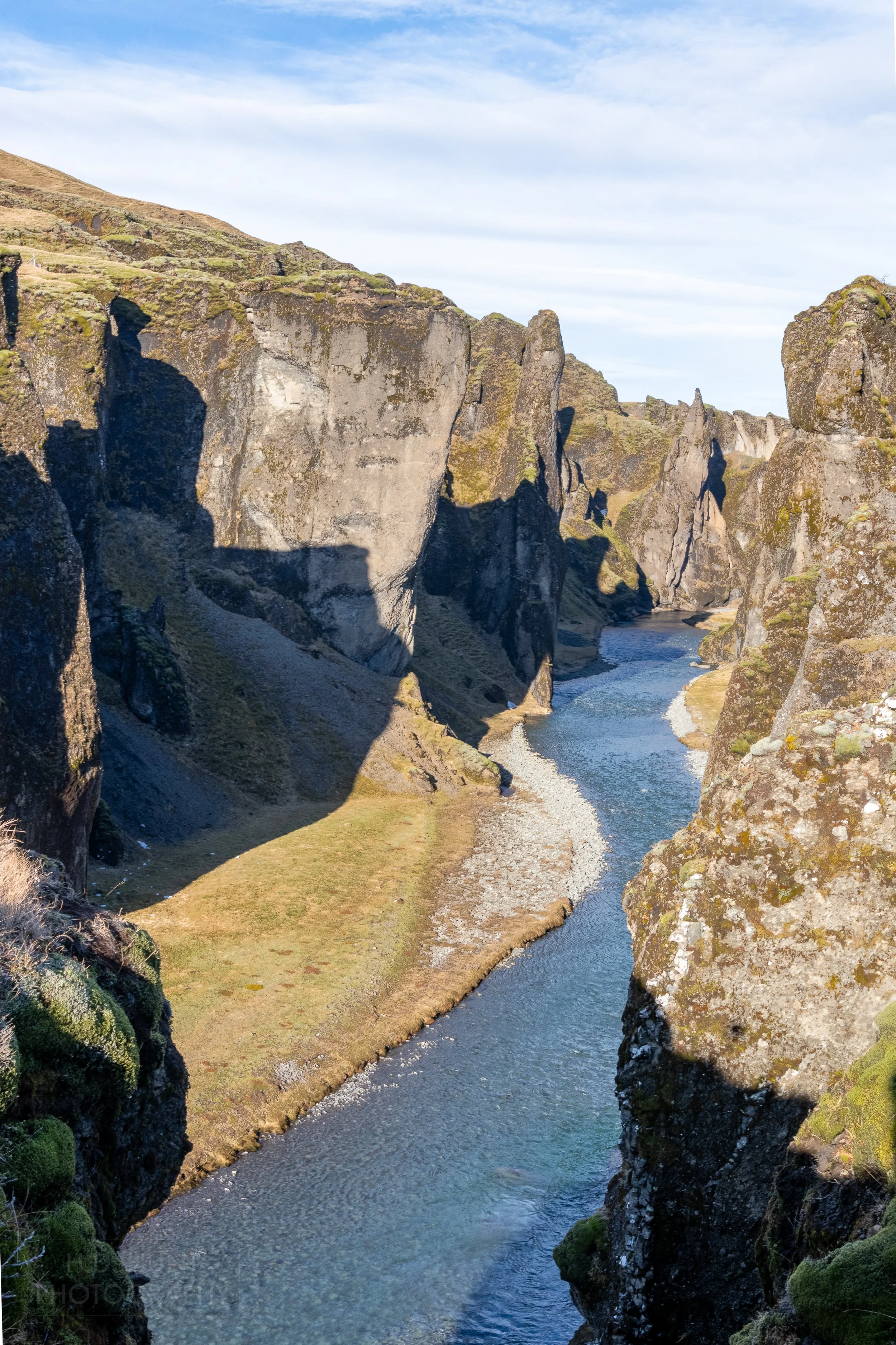 A river runs through a deep canyon at Fjaðrárgljúfur, Iceland.