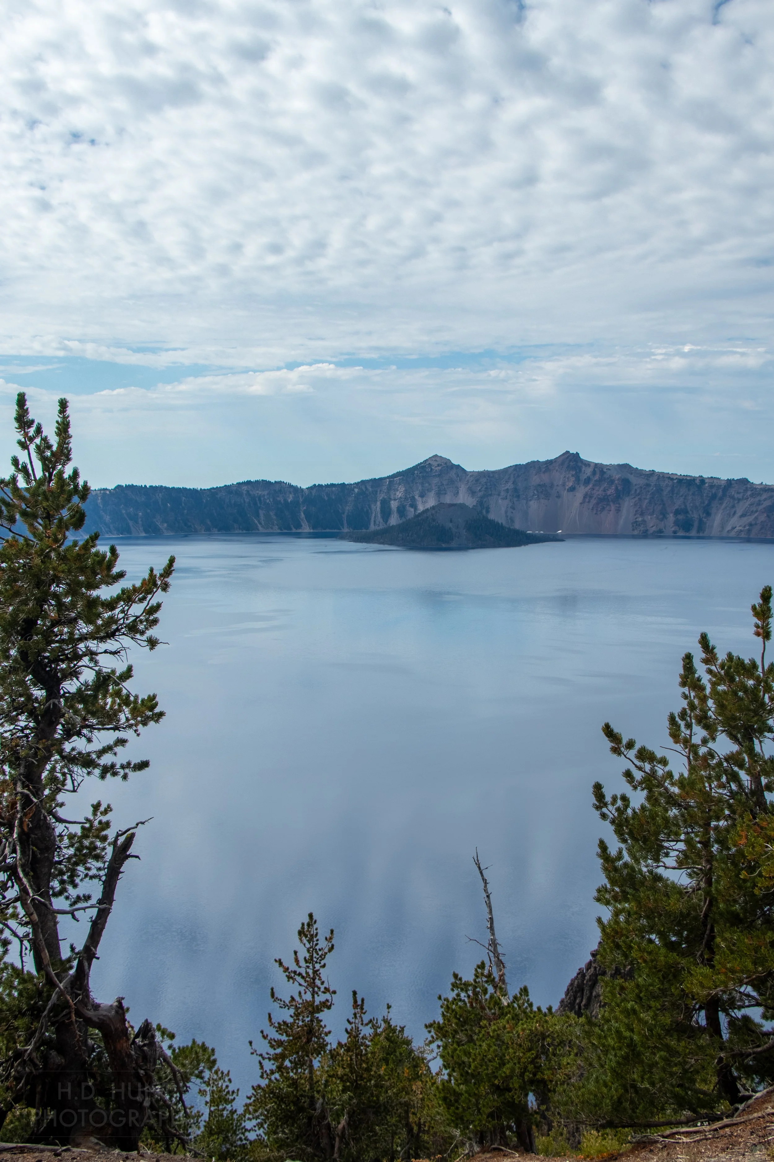 A view of Crater Lake with Wizard Island far in the background across Crater Lake, Oregon, United States.