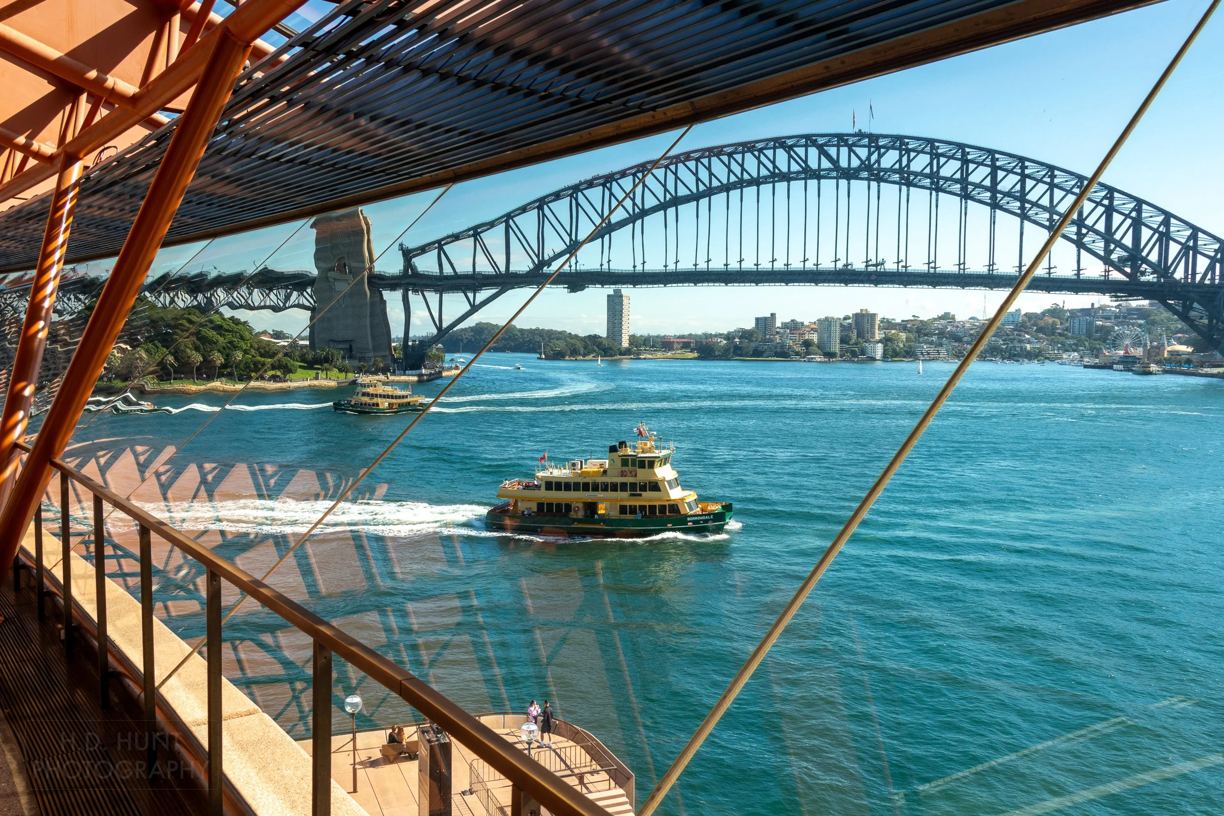 A ferry boat and the Sydney Harbour Bridge are seen through the rear window of the Sydney Opera House, Sydney, New South Wales, Australia.
