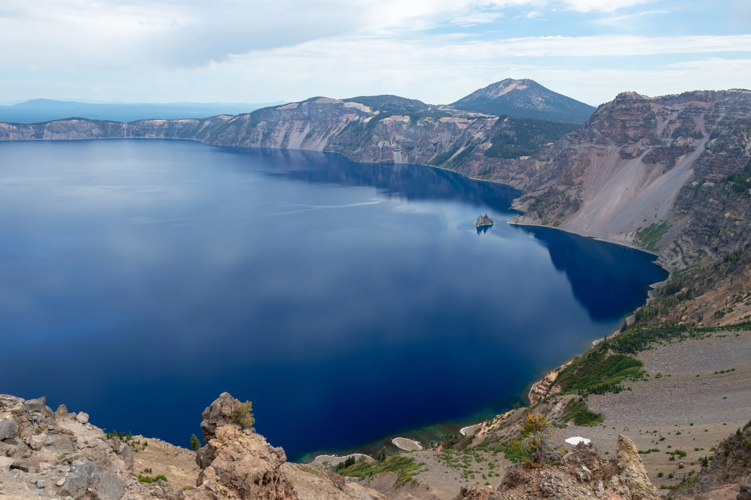 A view of the blue waters of Crater Lake, as well as the rocky outcrop Phantom Ship, from Garfield Peak, Crater Lake National Park, Oregon, United States.